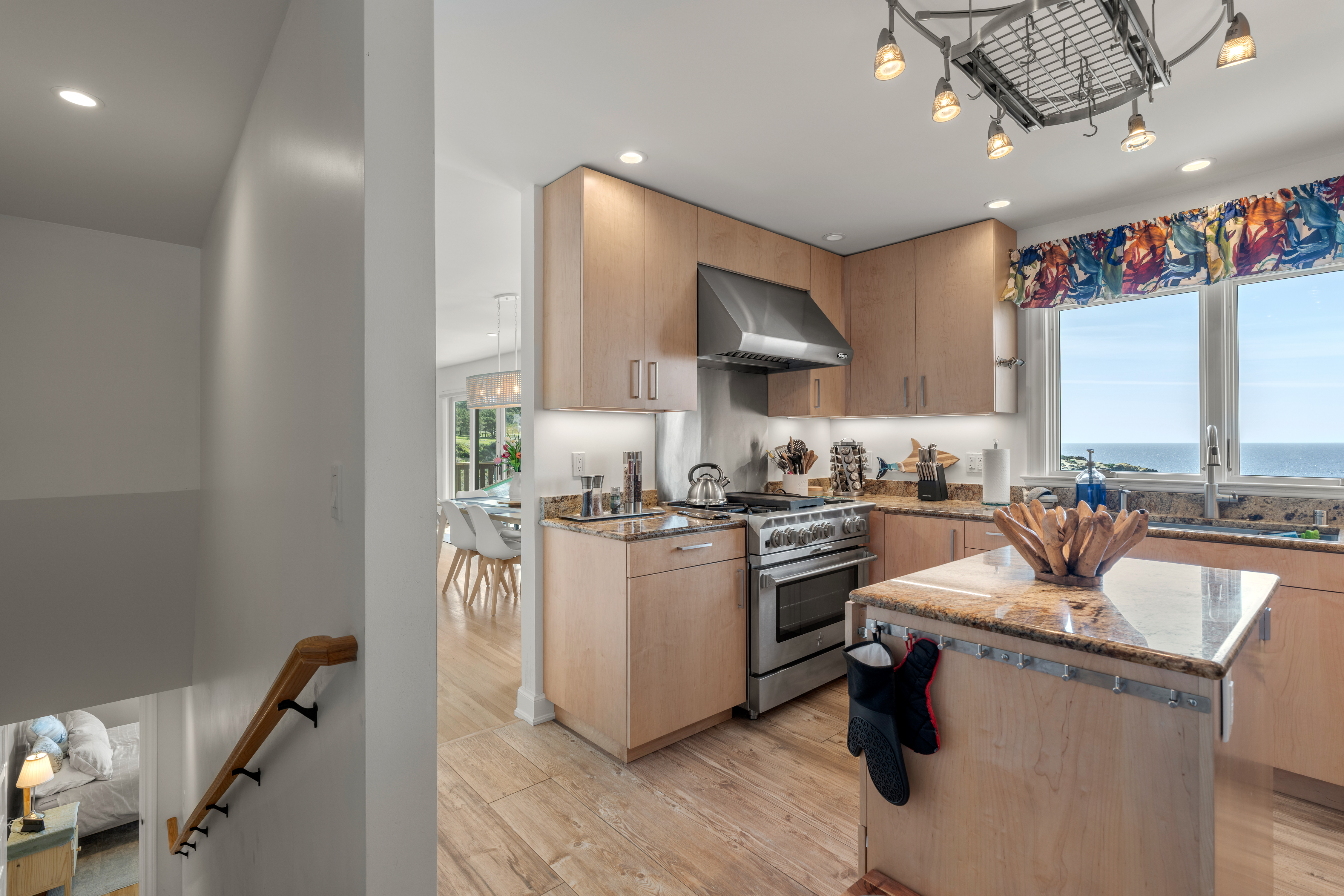 Chef’s kitchen with granite, gas range, and ocean-view windows