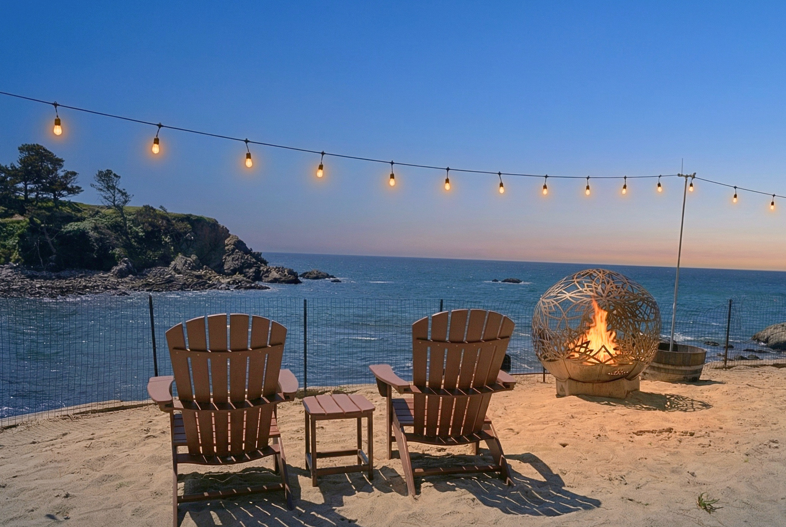 Oceanfront fire pit lounge with sunset views and cozy Adirondack seating