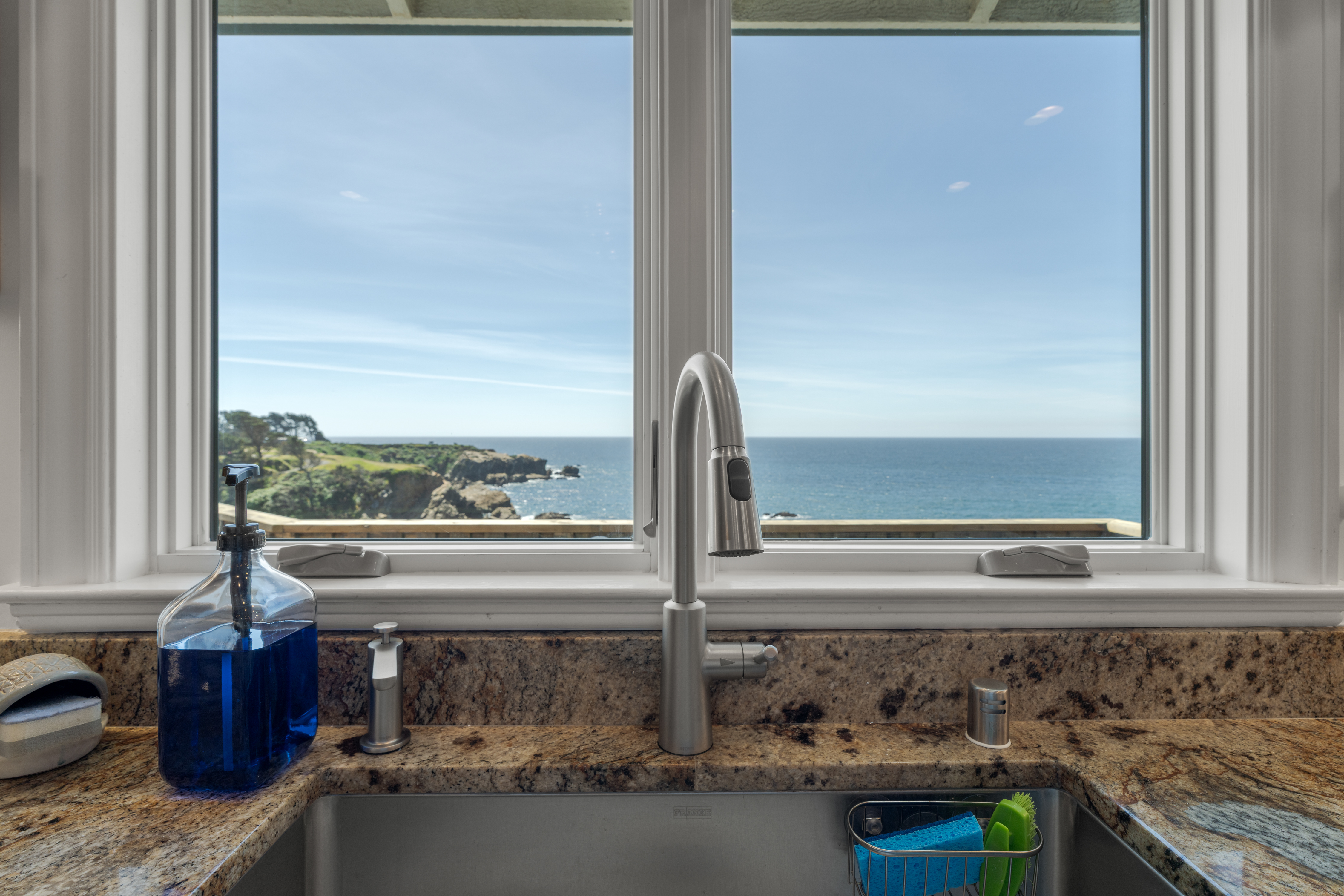 Ocean-view kitchen with granite counters and bright natural light