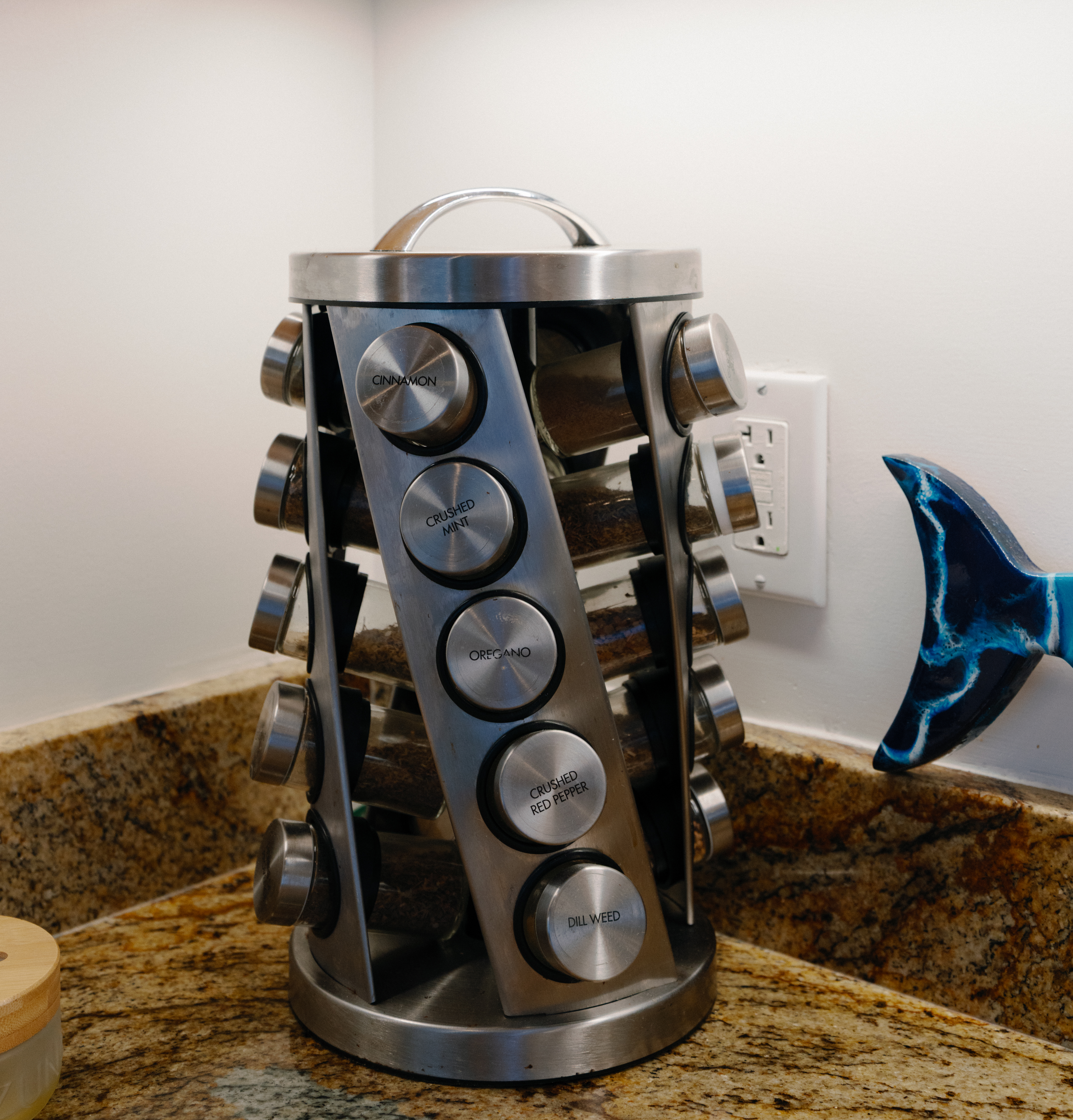 Stainless rotating spice rack on granite—cook with stocked seasonings.