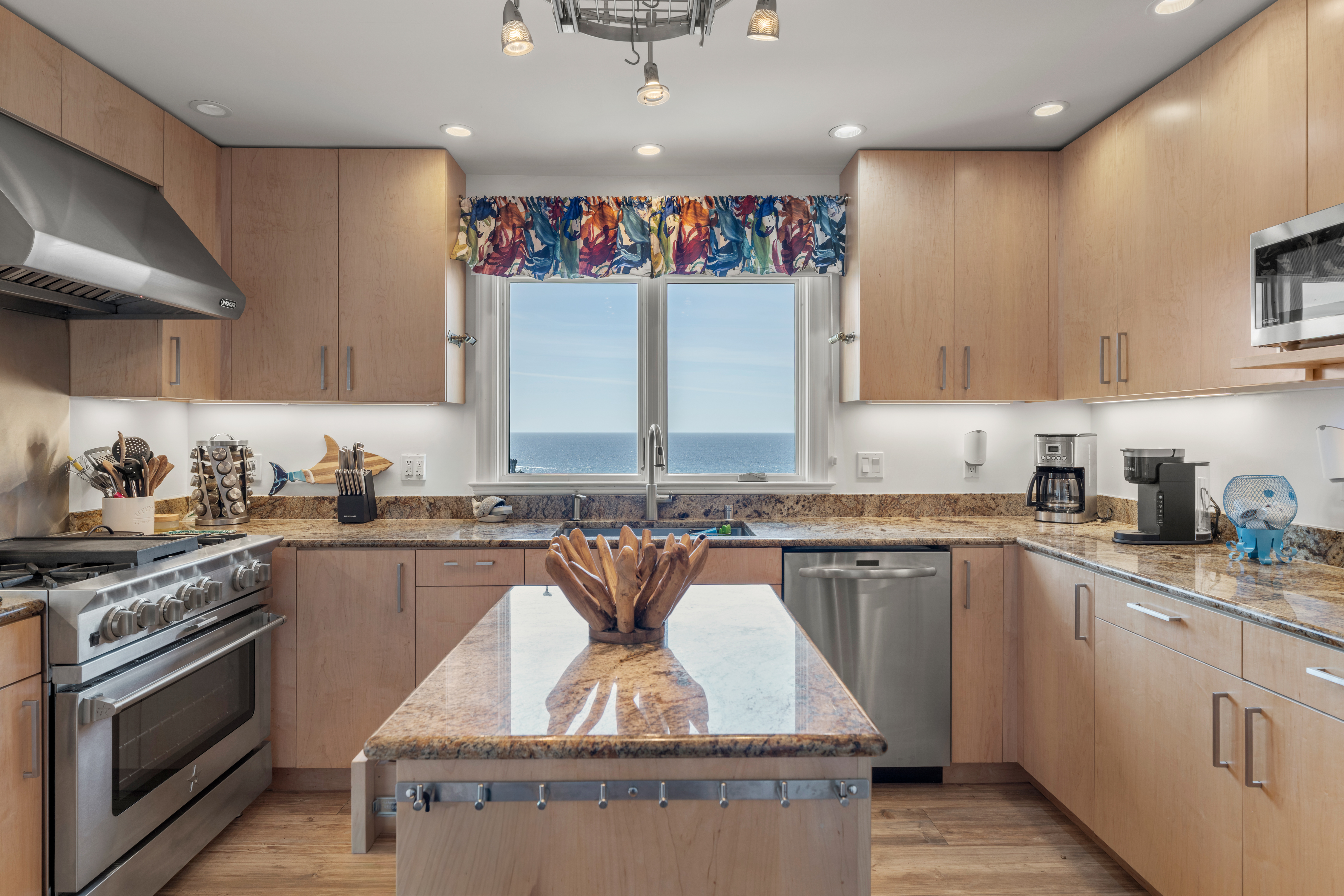 Ocean-view chef’s kitchen with island, granite, and pro range