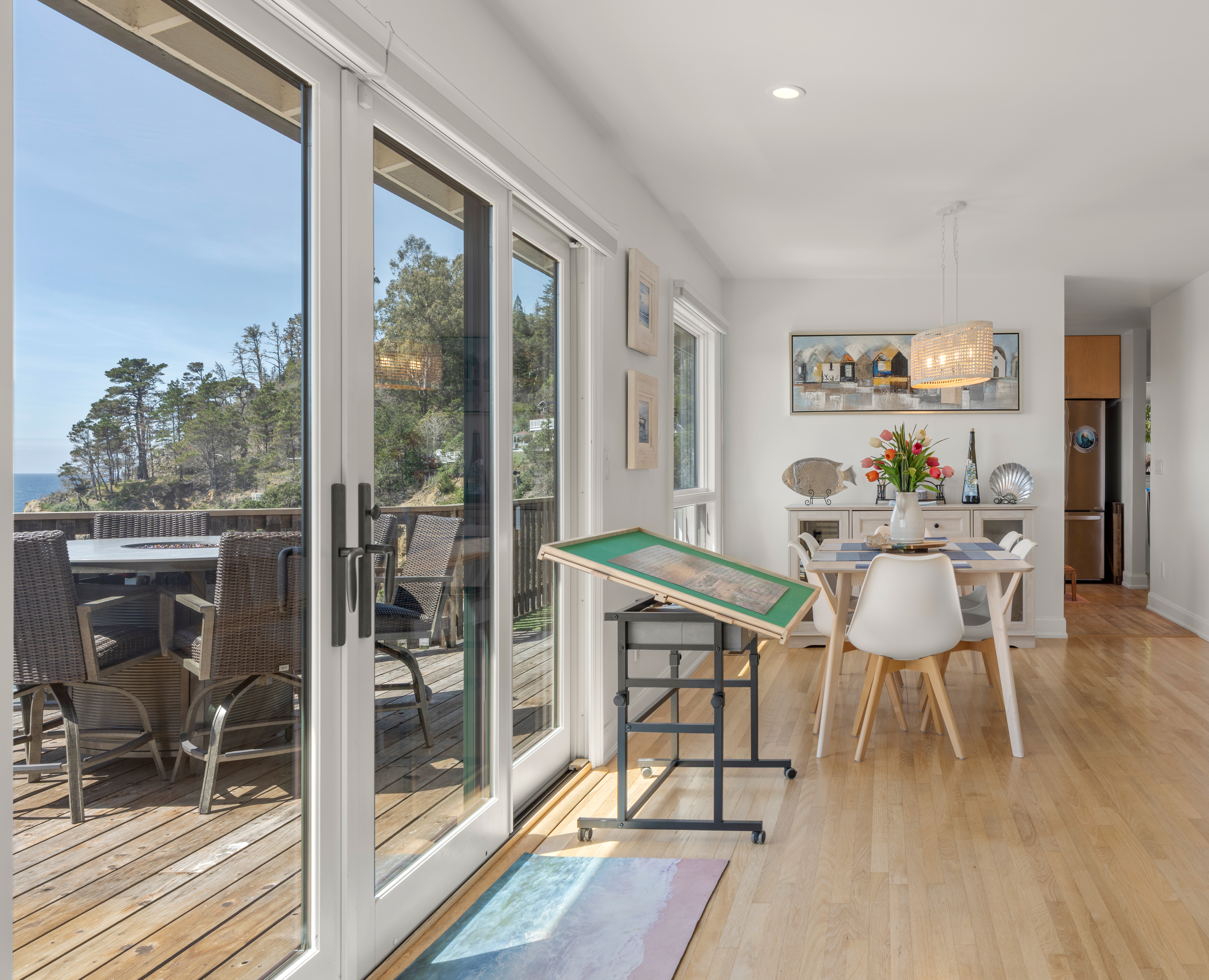 Sunlit dining opens to deck with ocean views and alfresco seating