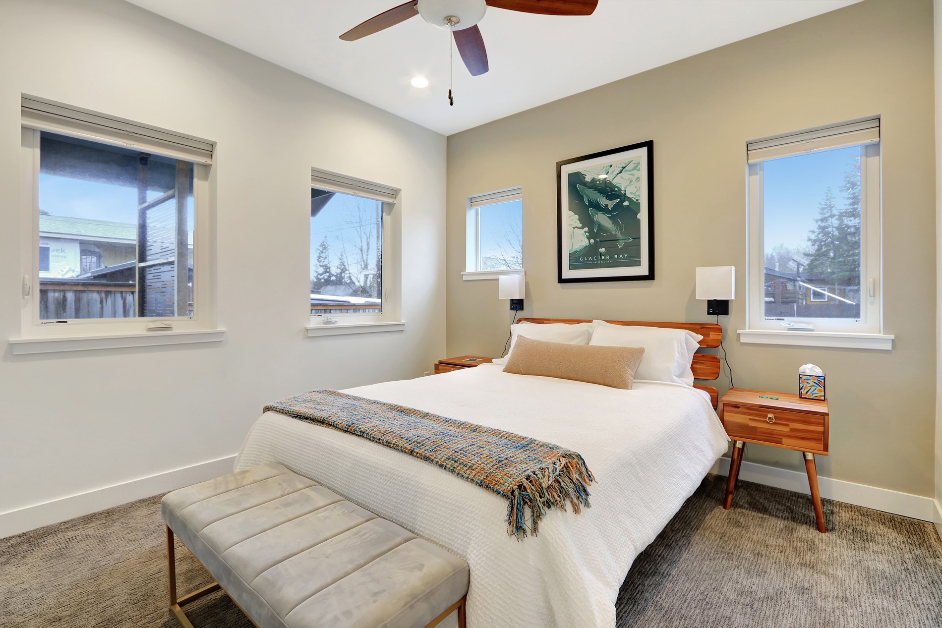 Bright modern bedroom with cozy seating, natural light, and stylish decor
