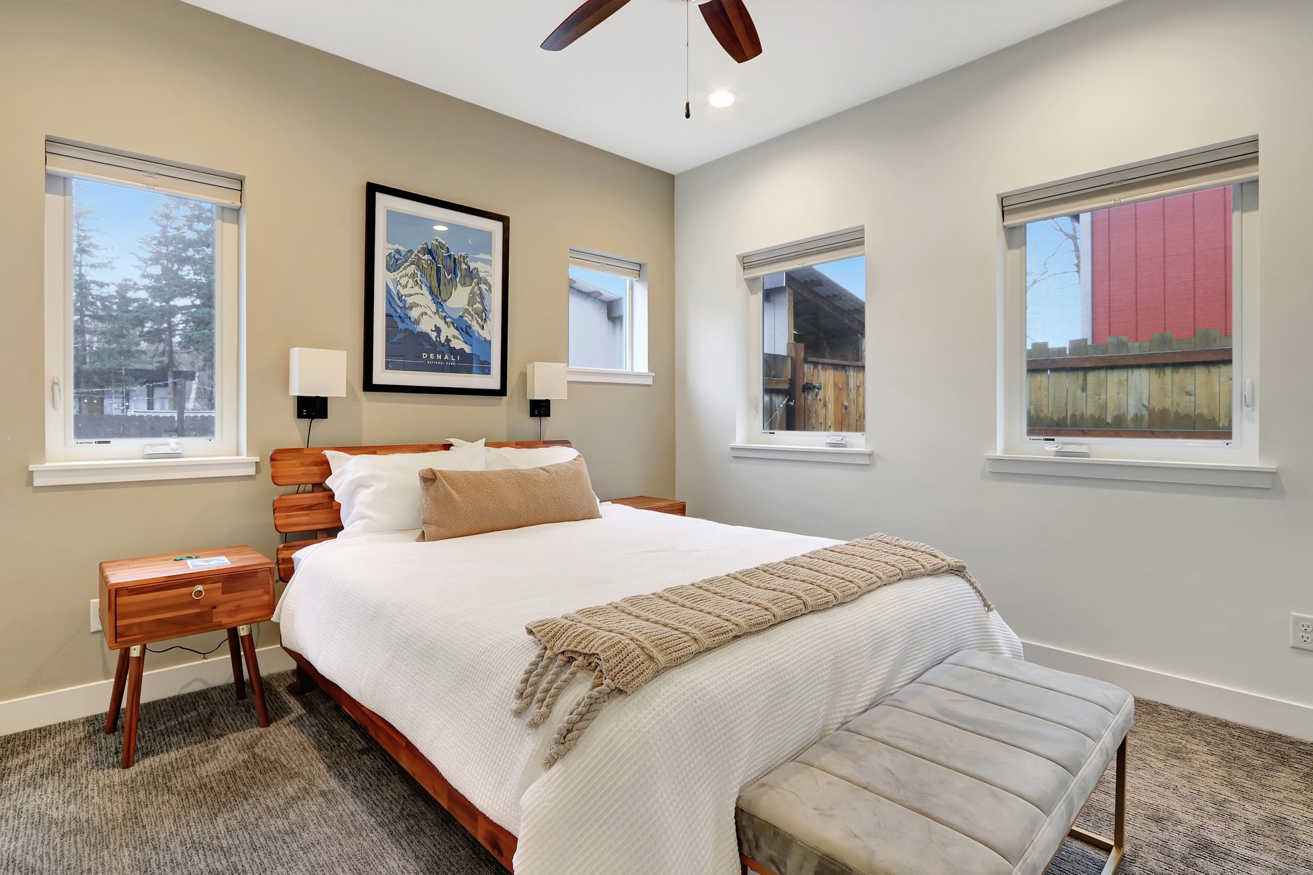 Bright modern bedroom with cozy bedding, natural light, and stylish wood accents