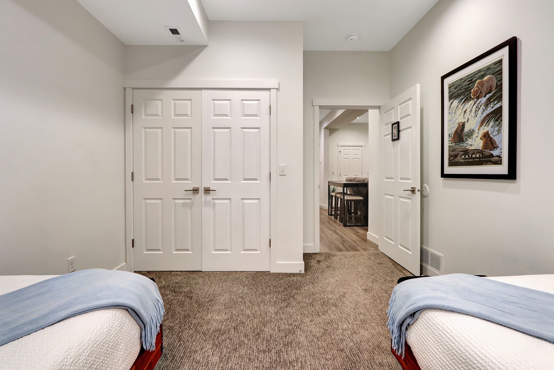 Bright twin bedroom with soft carpet, closet space, and easy home access