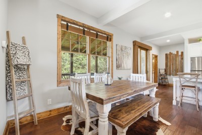 Rustic dining nook with barn doors, forest views & open kitchen