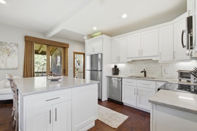 Bright chef’s kitchen with quartz island, stainless steel and deck access