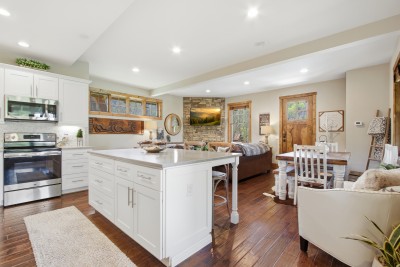 Bright open kitchen with island, rustic lounge and stone fireplace
