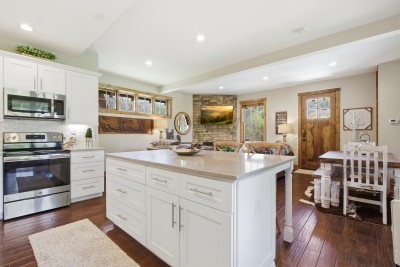 Bright chef’s kitchen and cozy lounge by stone fireplace with views