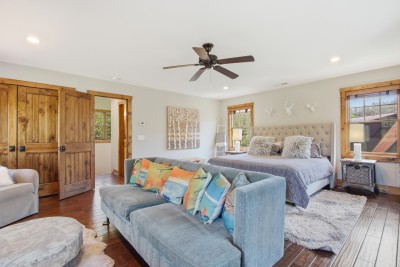 Bright king suite with cozy lounge, rustic wood accents, and natural light