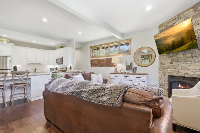 Cozy open-plan living with stone fireplace and chef’s kitchen