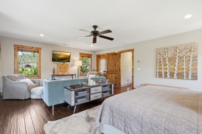 Spacious bedroom suite with cozy lounge, rich hardwoods & rustic charm