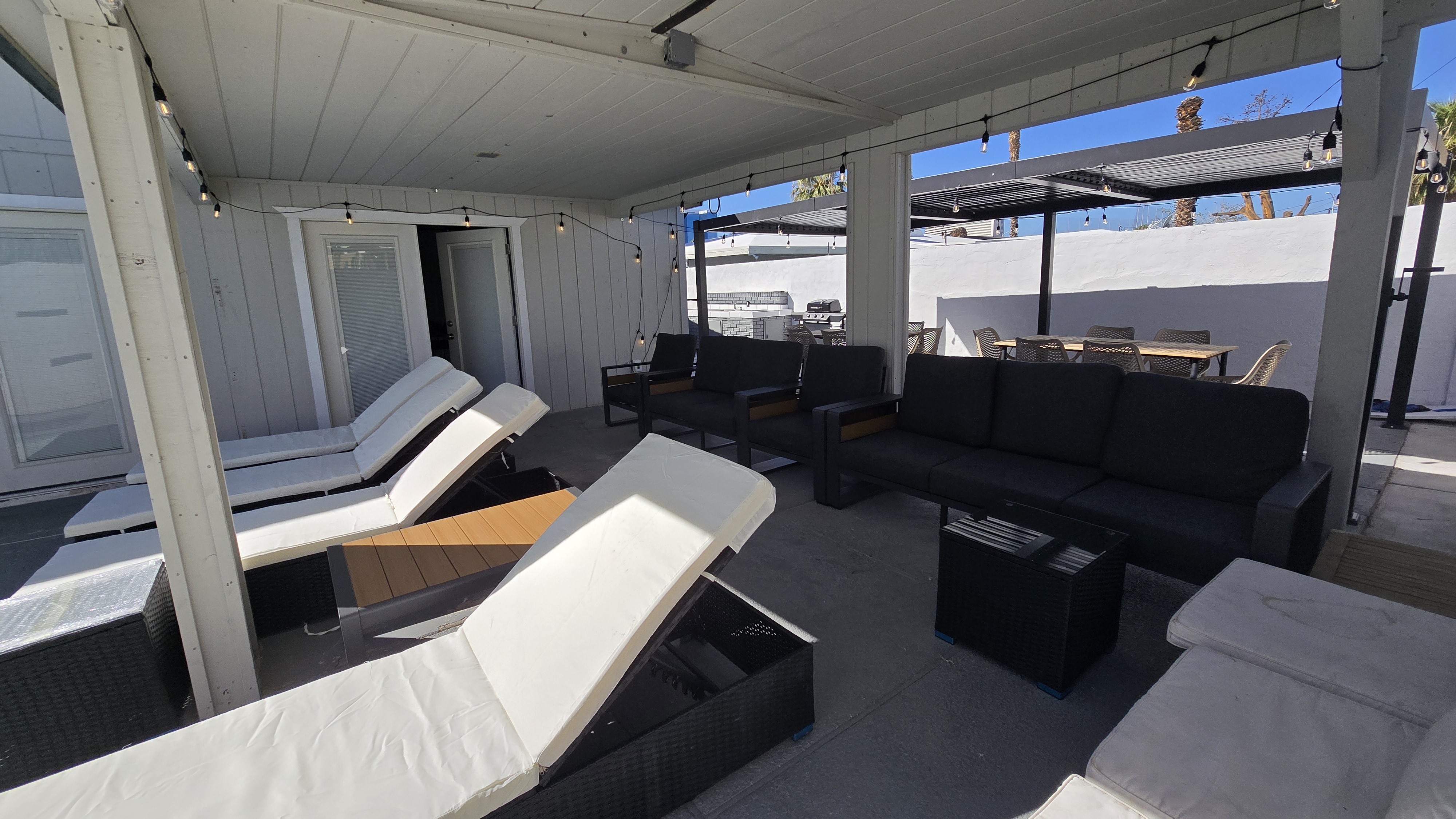 Covered lounge patio with chaise seating and outdoor dining