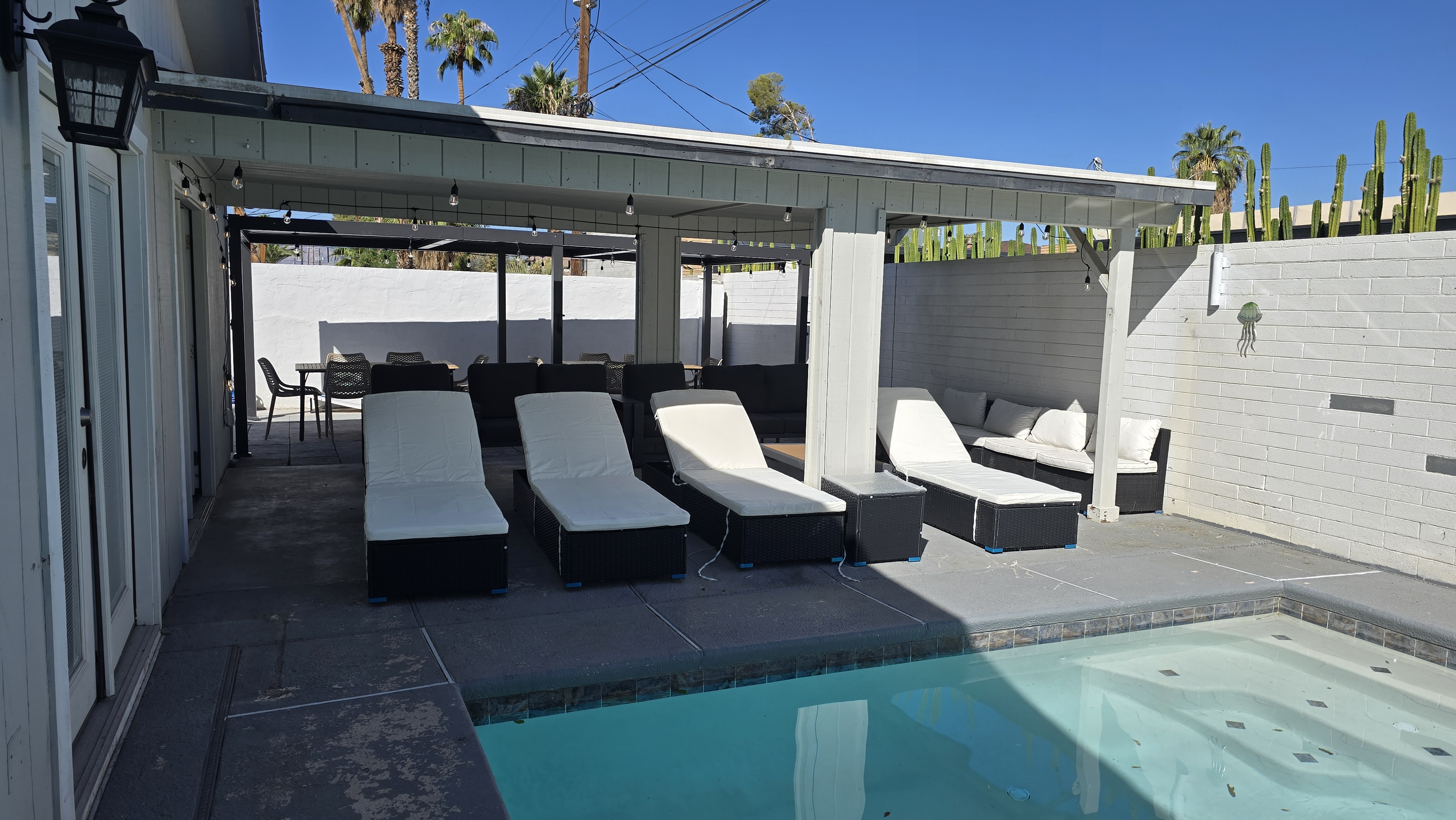 Private poolside patio with loungers, shaded seating, and desert vibes