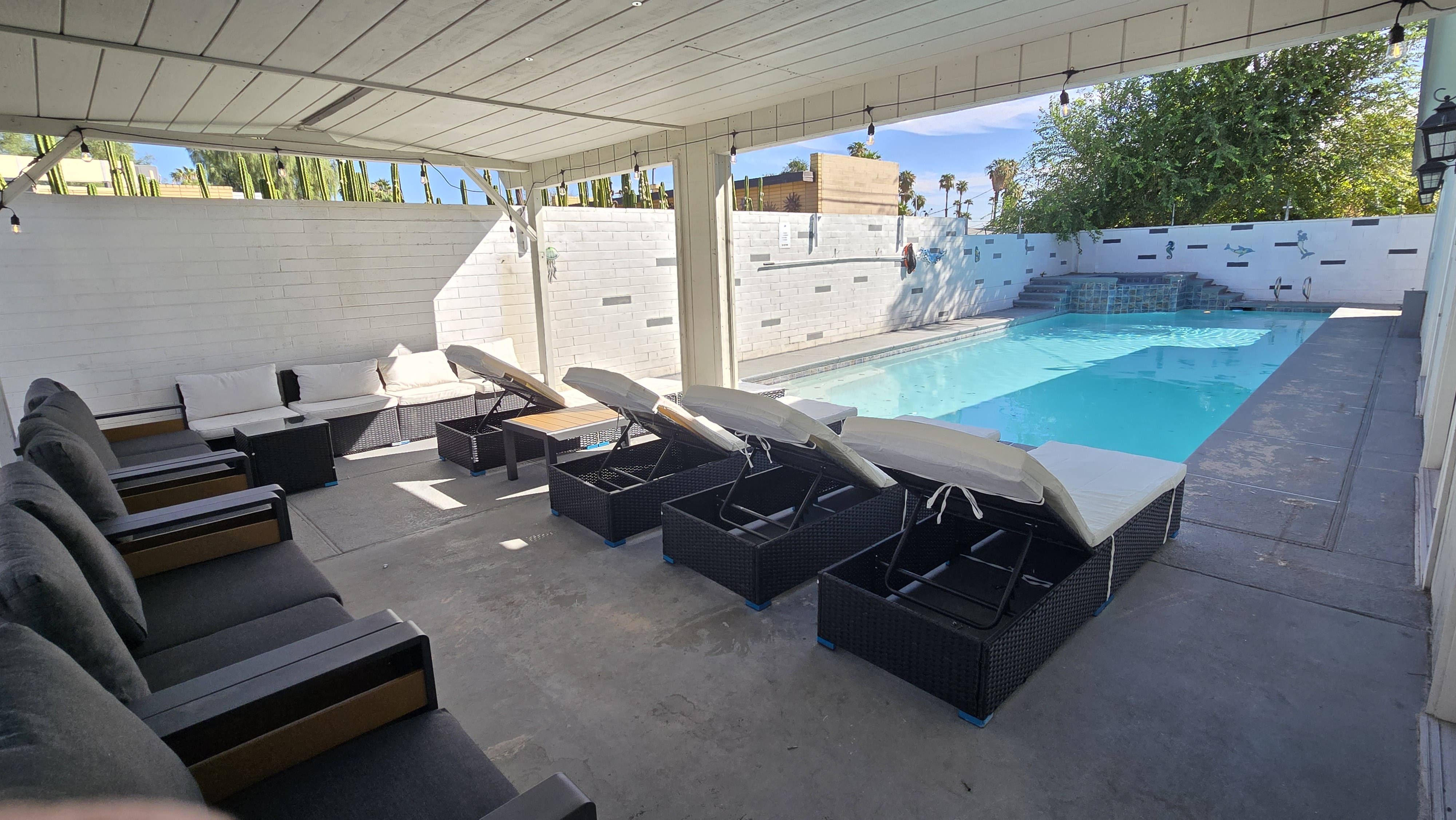 Private covered pool patio with loungers and stylish outdoor seating