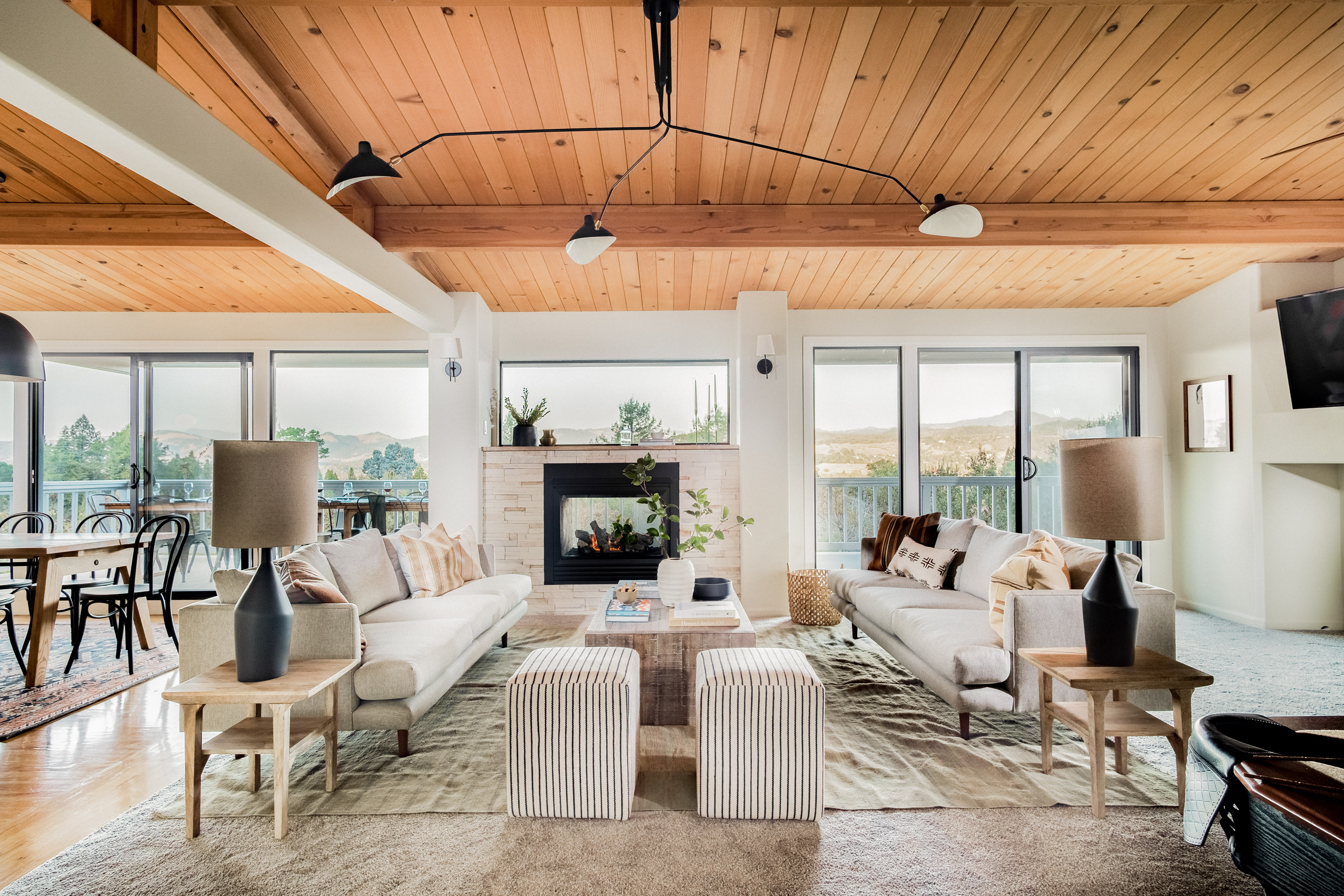 Bright mountain-view living room with fireplace and soaring wood ceilings