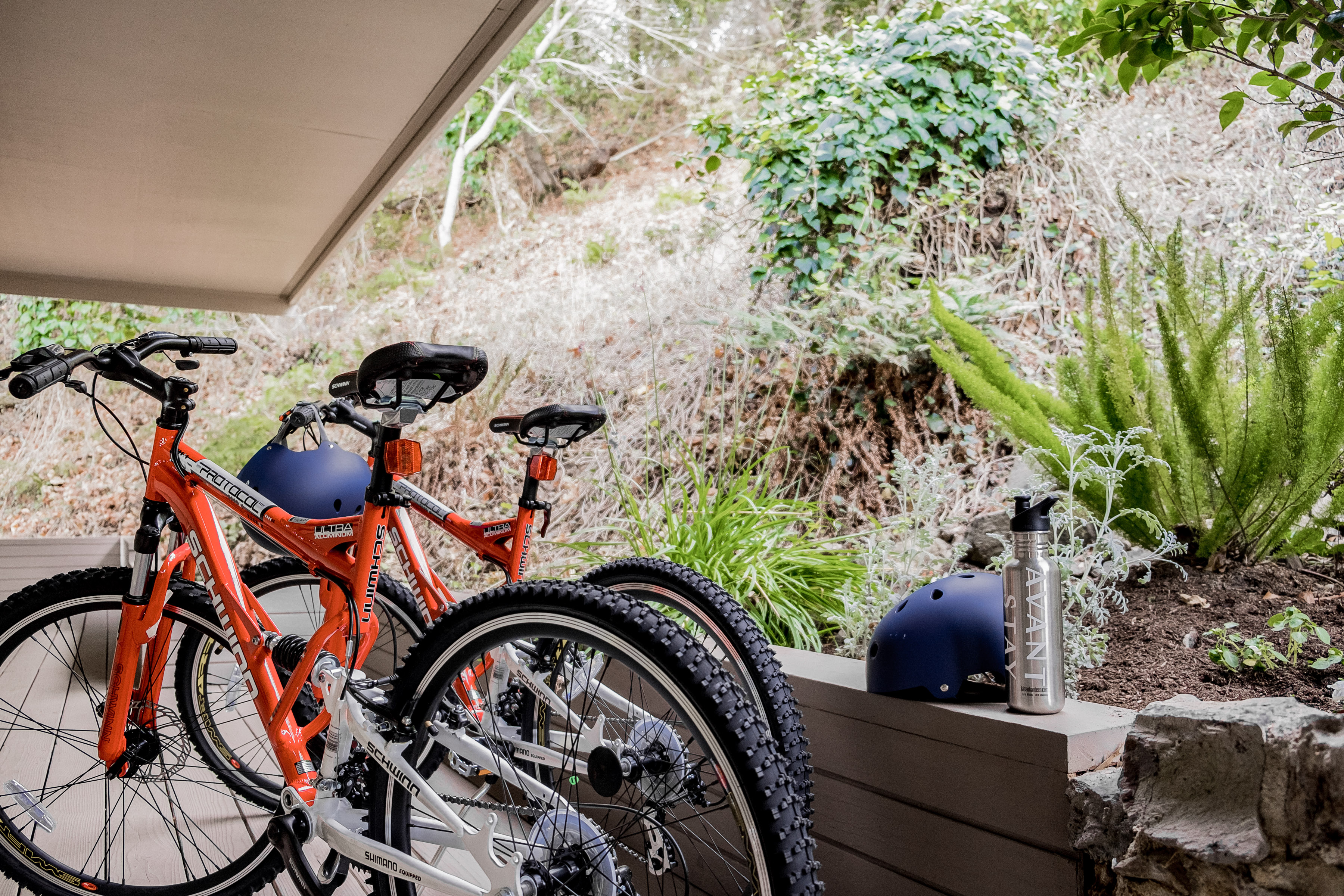 Adventure-ready patio with bikes, helmet, and serene garden views