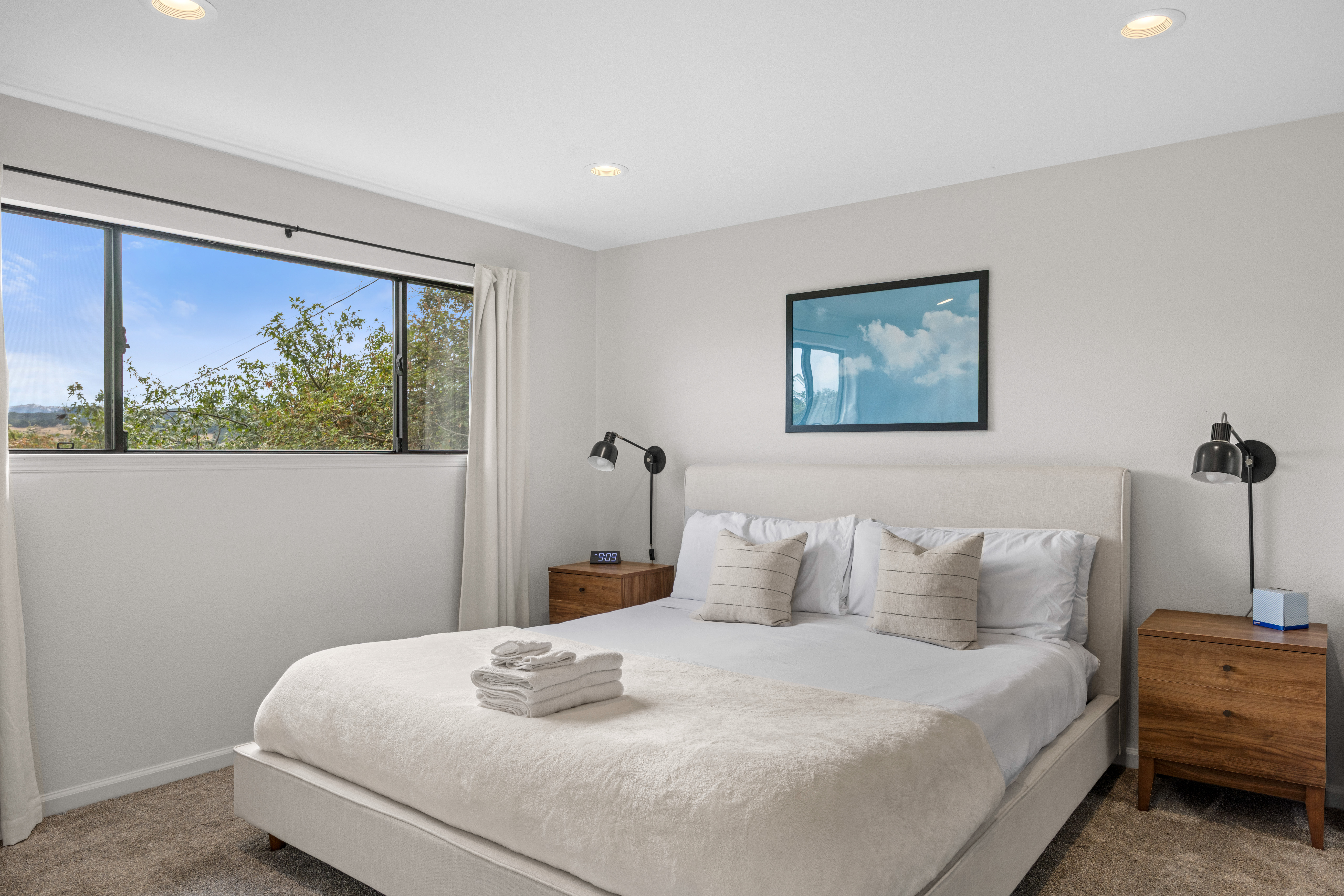 Bright, serene bedroom with plush king bed and sunny window views