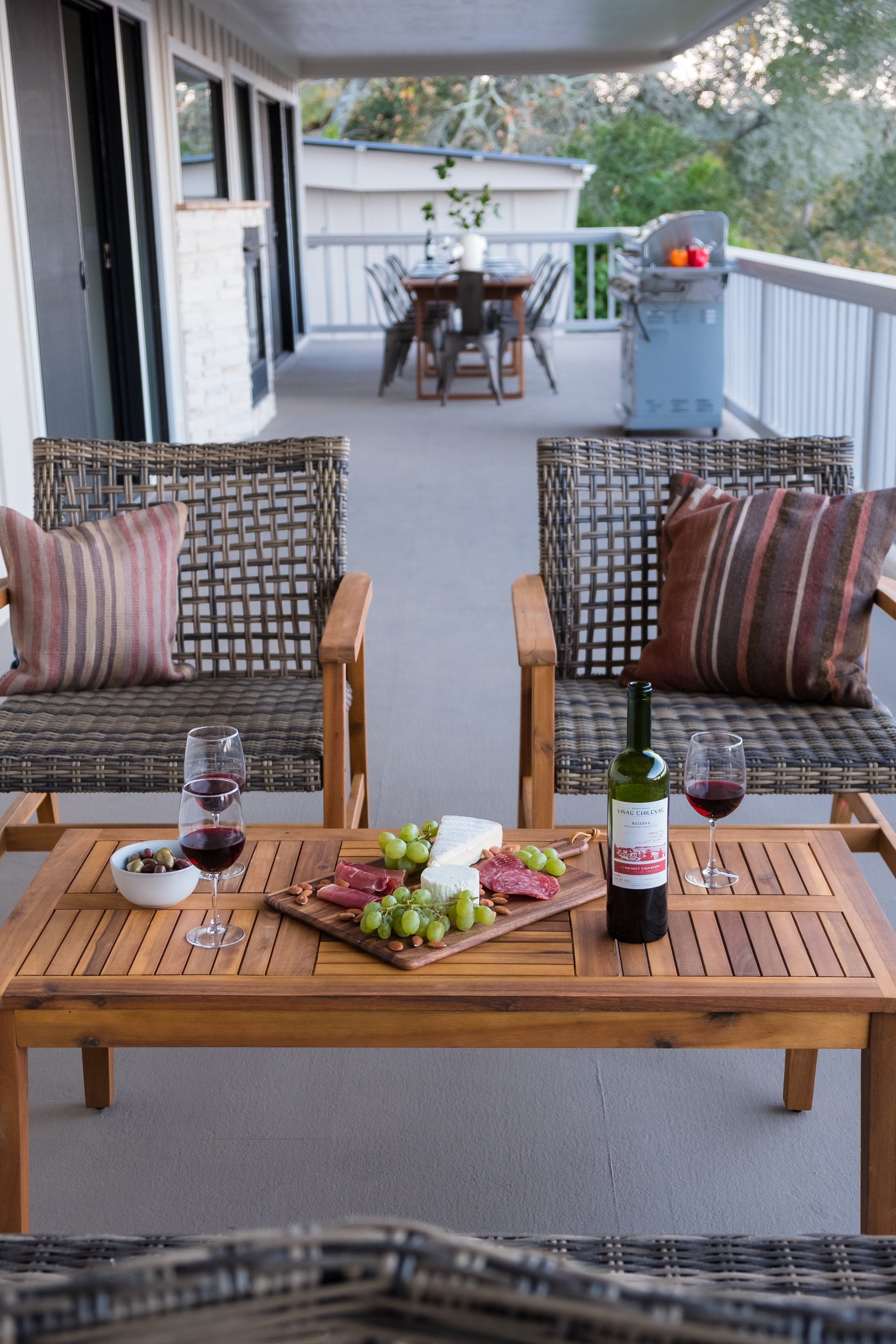Covered balcony with lounge seating, wine, grill, and outdoor dining