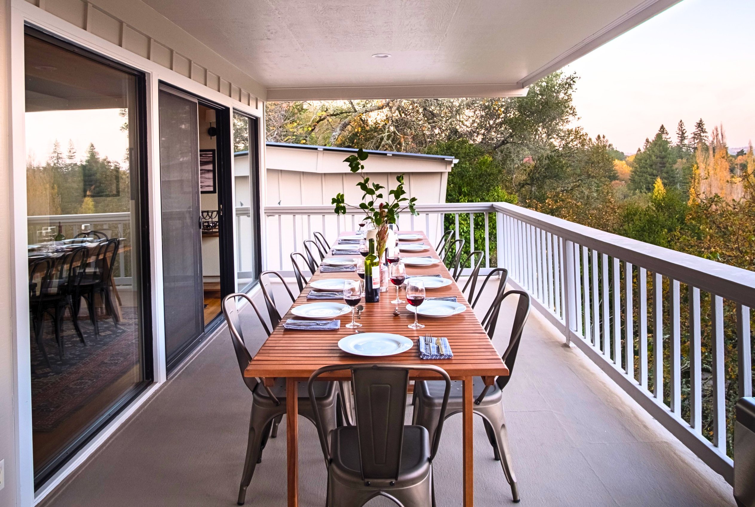 Covered balcony dining with treetop views and seating for the whole group