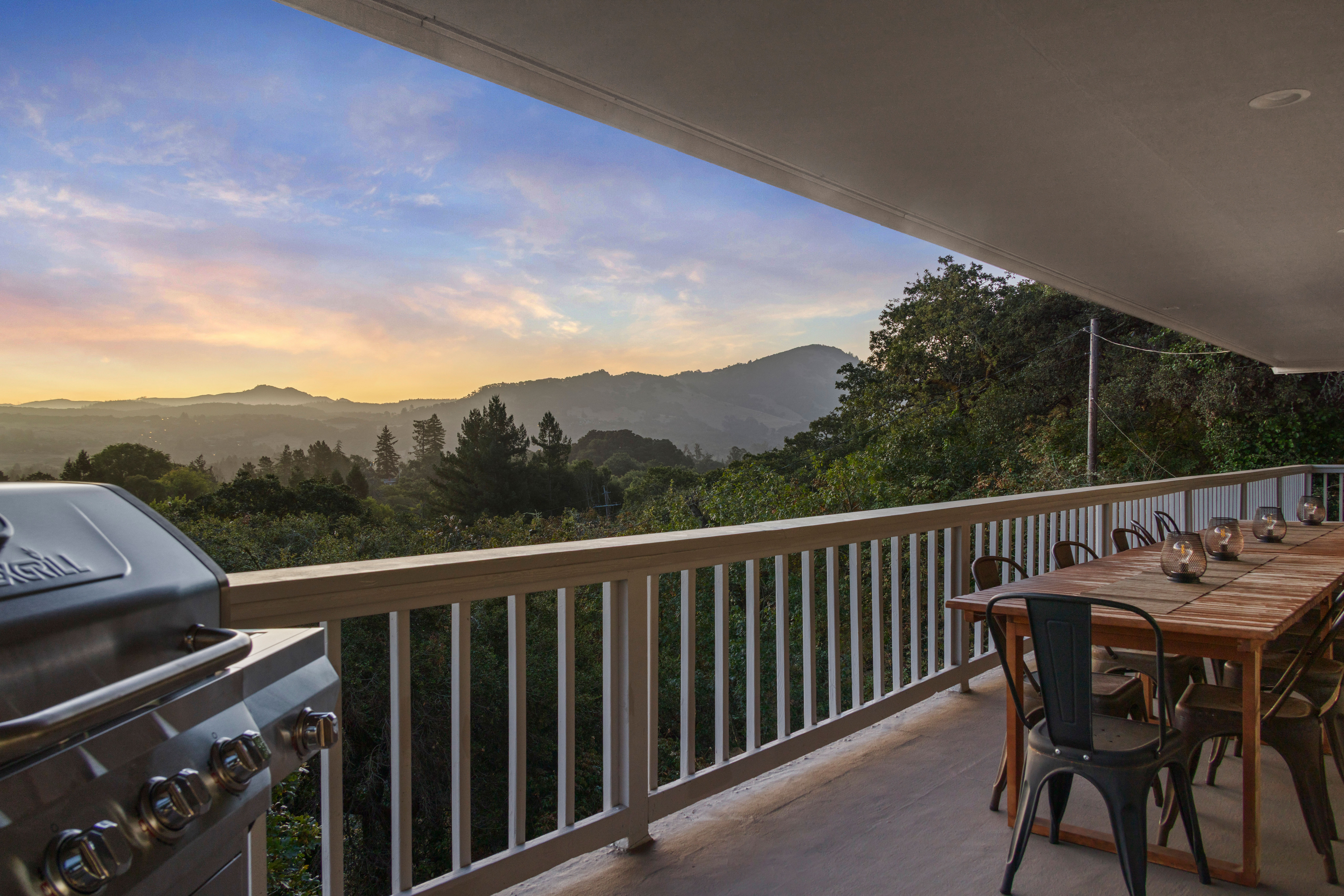Covered deck with grill, outdoor dining, and stunning sunset mountain views