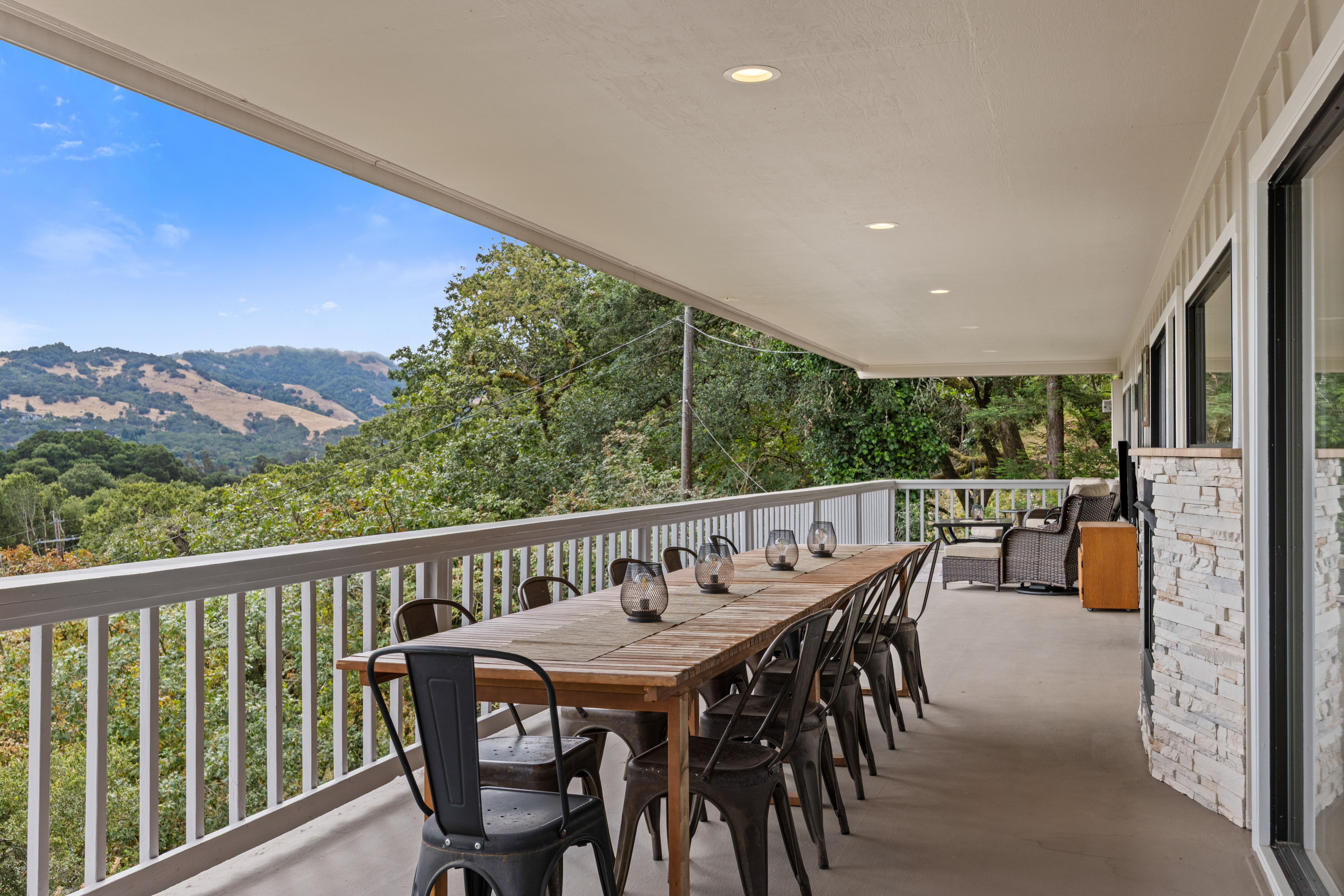 Covered view deck with outdoor dining and მშვიდ hillside scenery