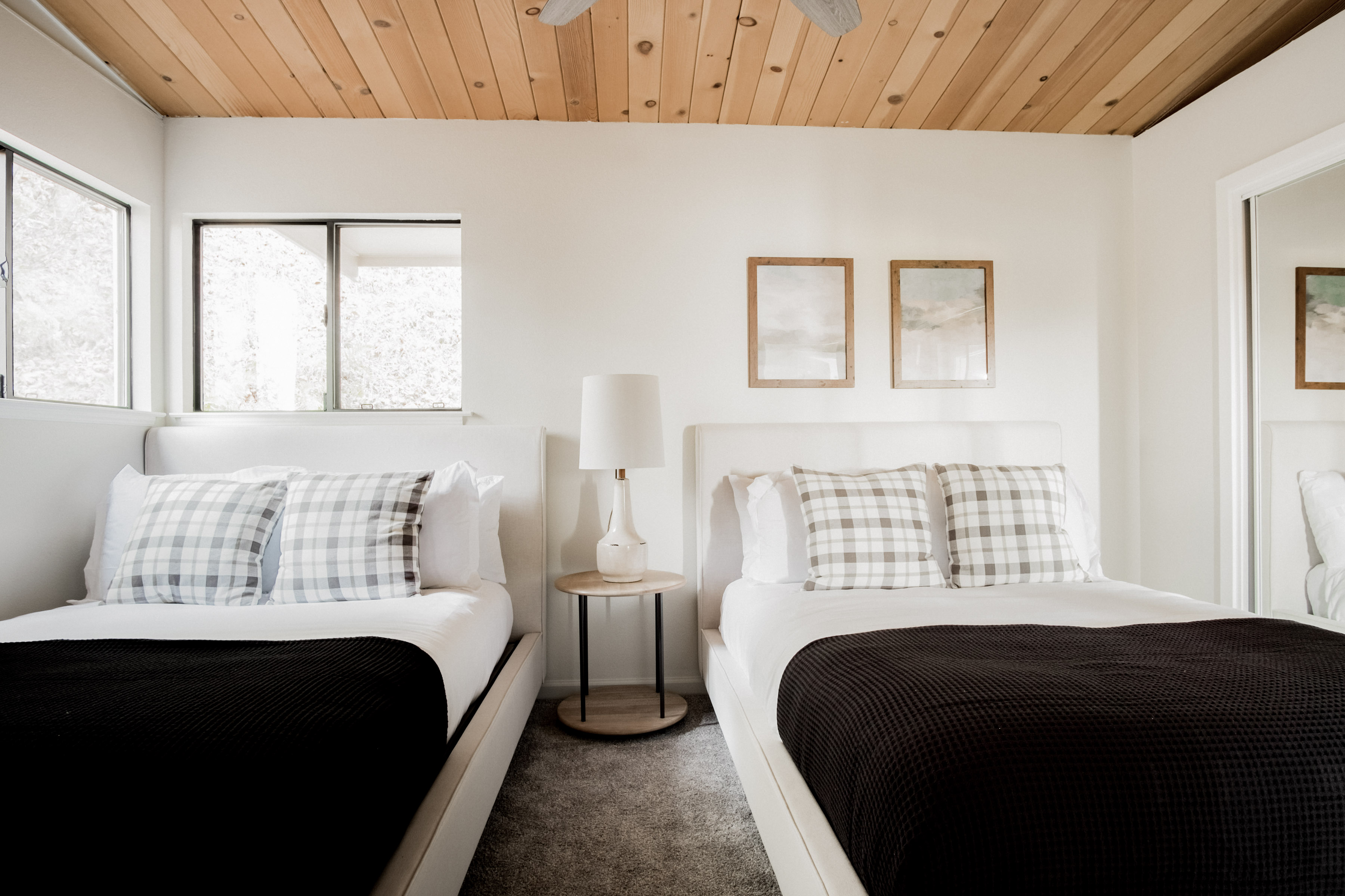 Bright double-bedroom with cozy beds, natural light, and warm wood ceilings