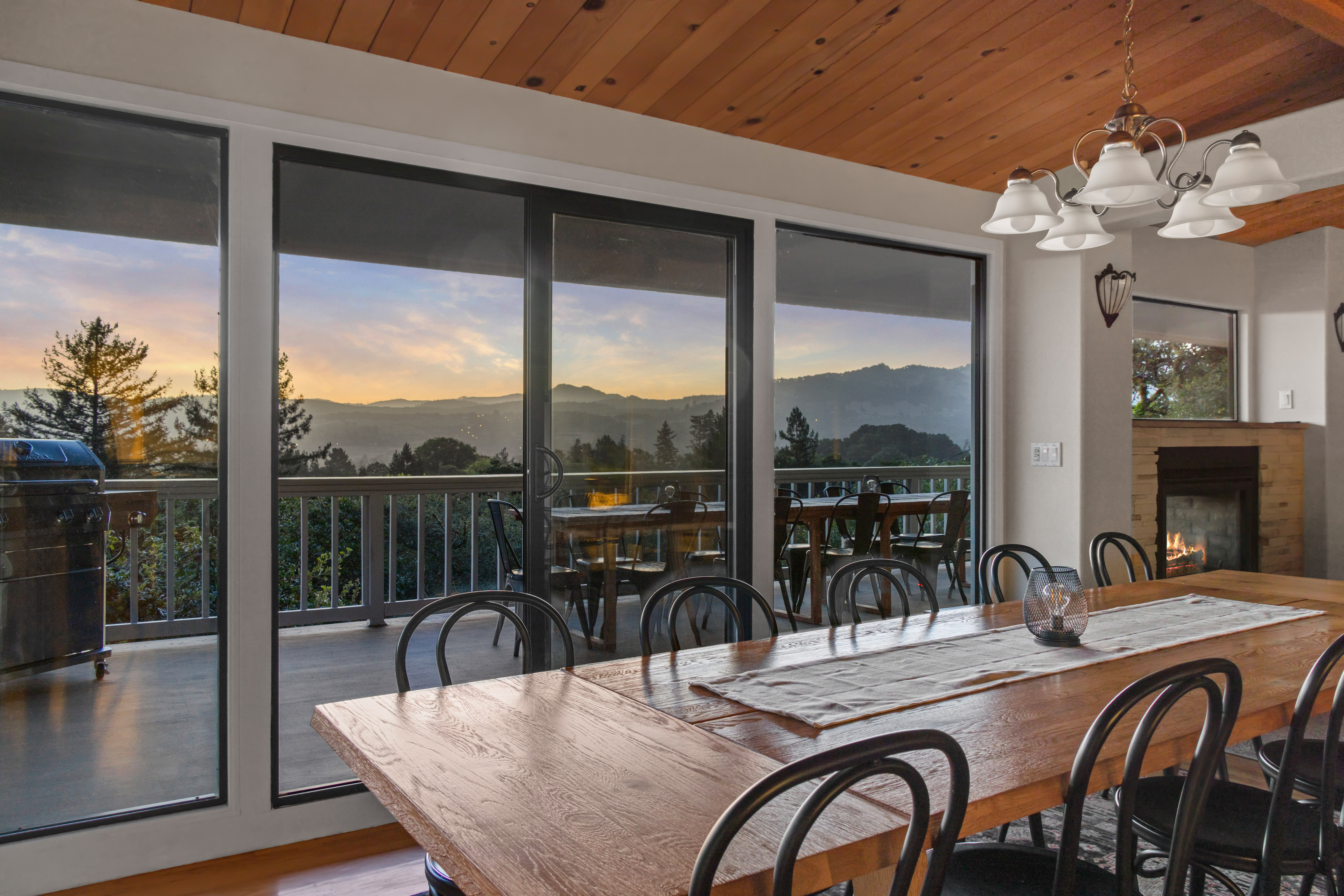 Scenic mountain-view dining room with balcony access and cozy fireplace