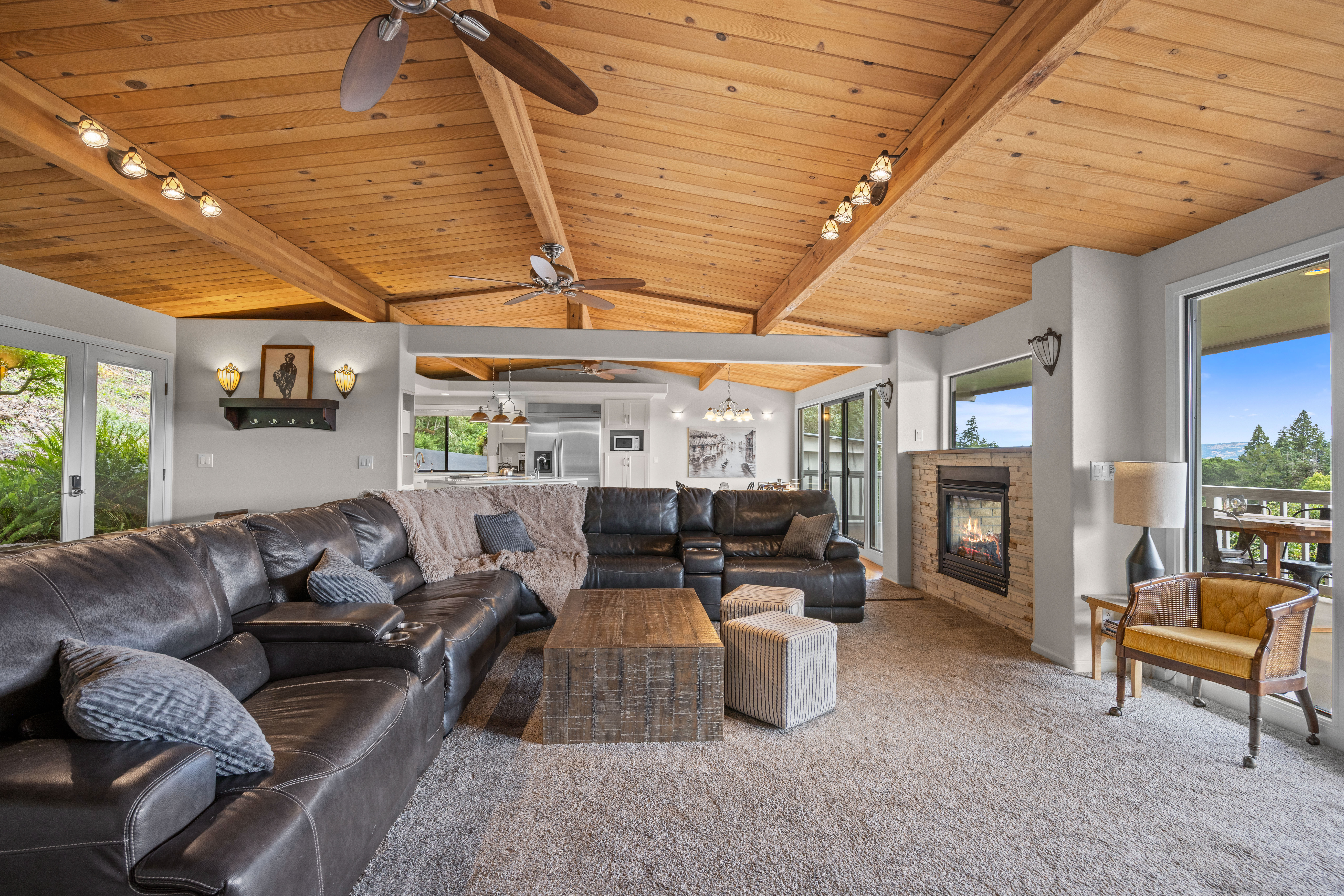 Spacious mountain-style living room with fireplace, deck views, and ample seating
