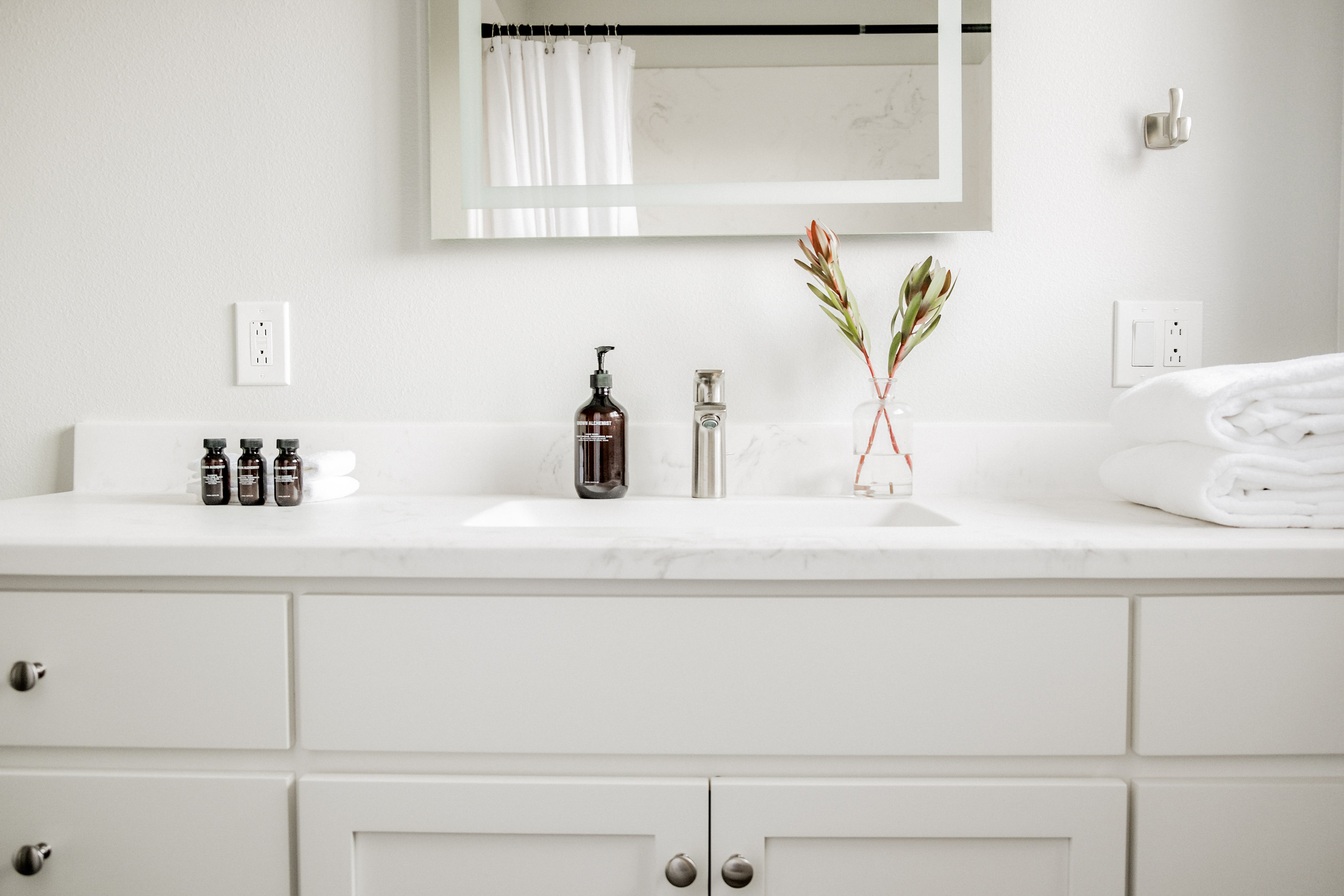 Bright modern bathroom vanity with fresh towels and elegant finishing touches