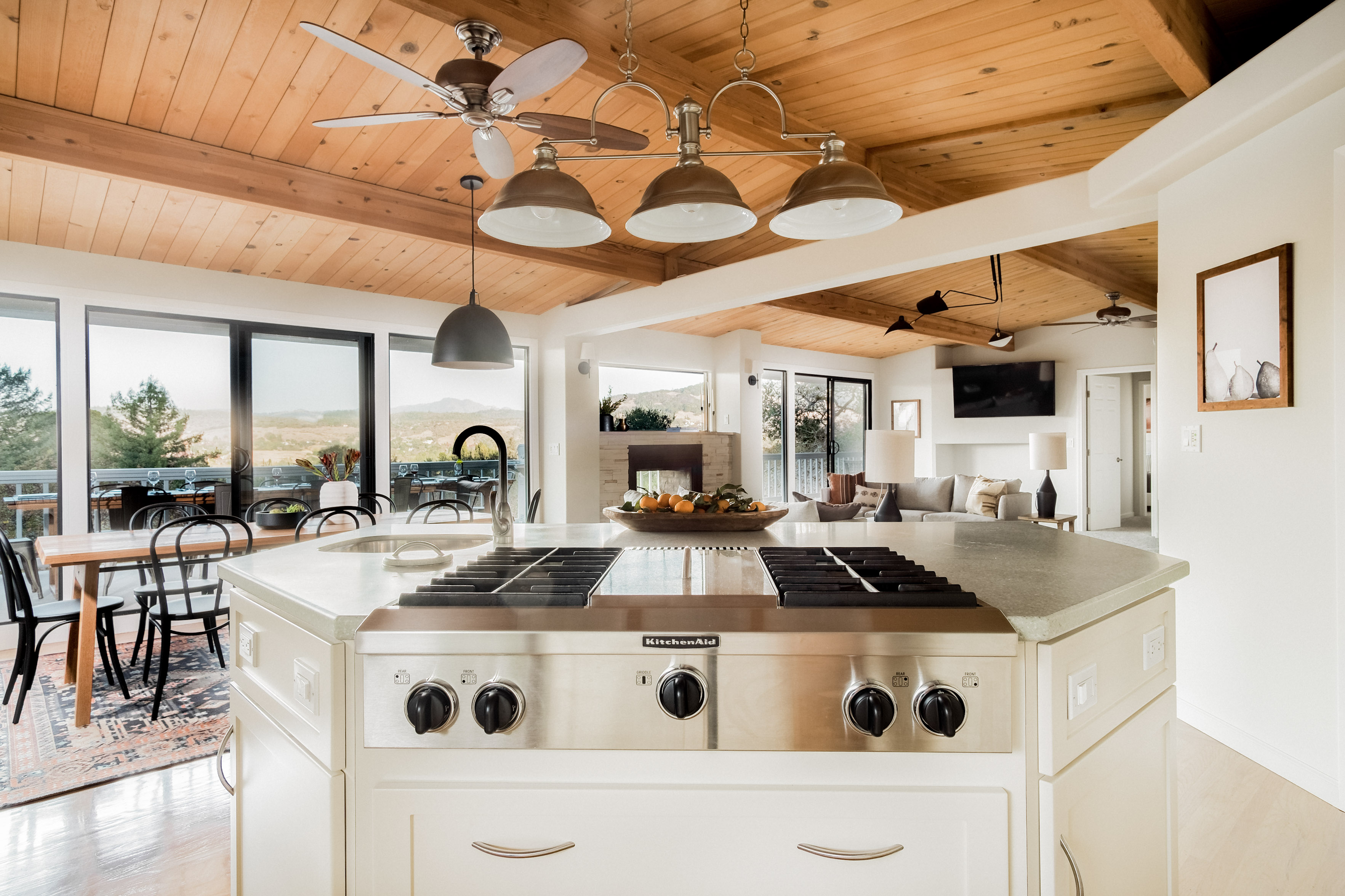 Bright open kitchen with scenic views, wood ceilings, and a spacious island