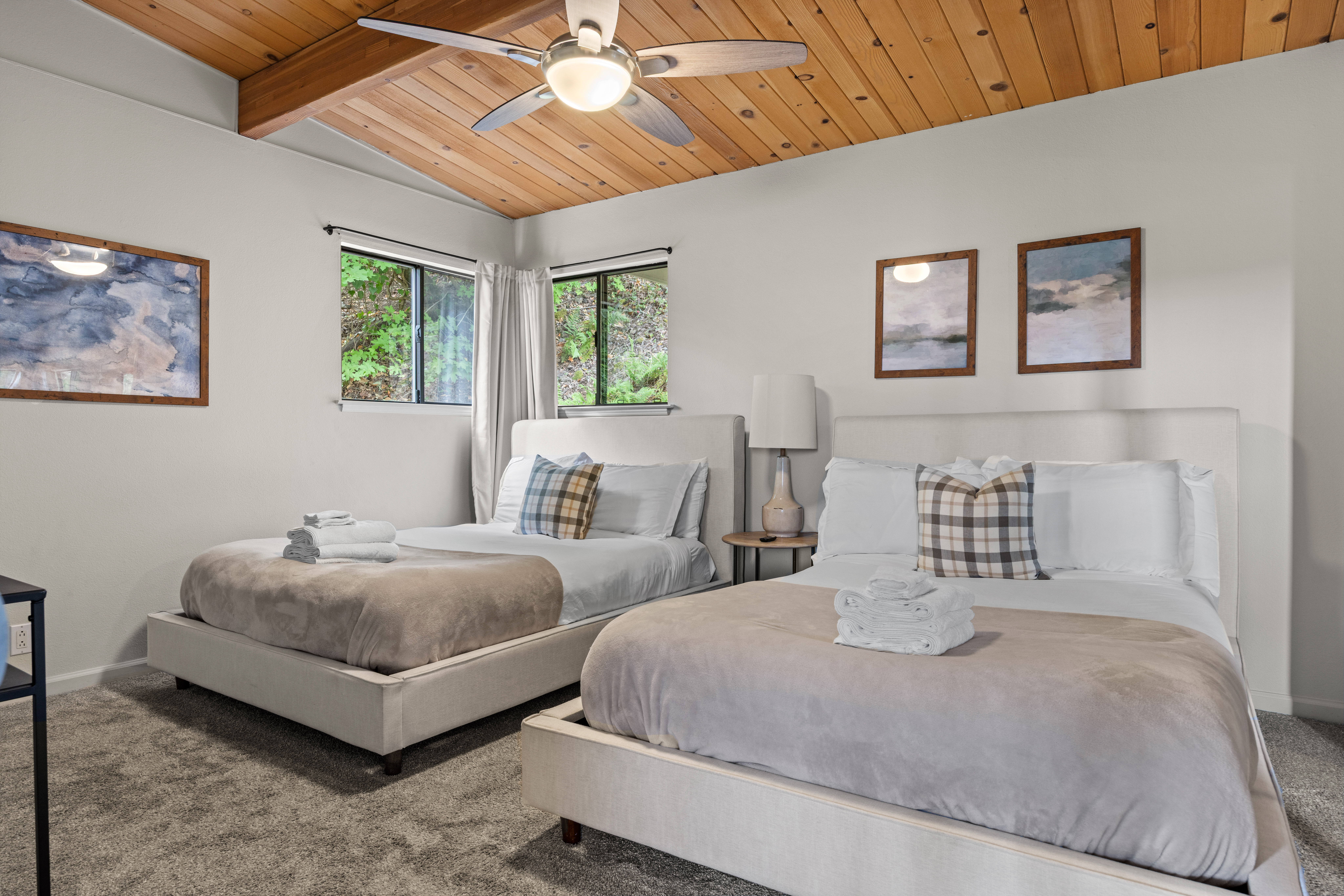 Spacious double-queen bedroom with vaulted wood ceilings and natural light