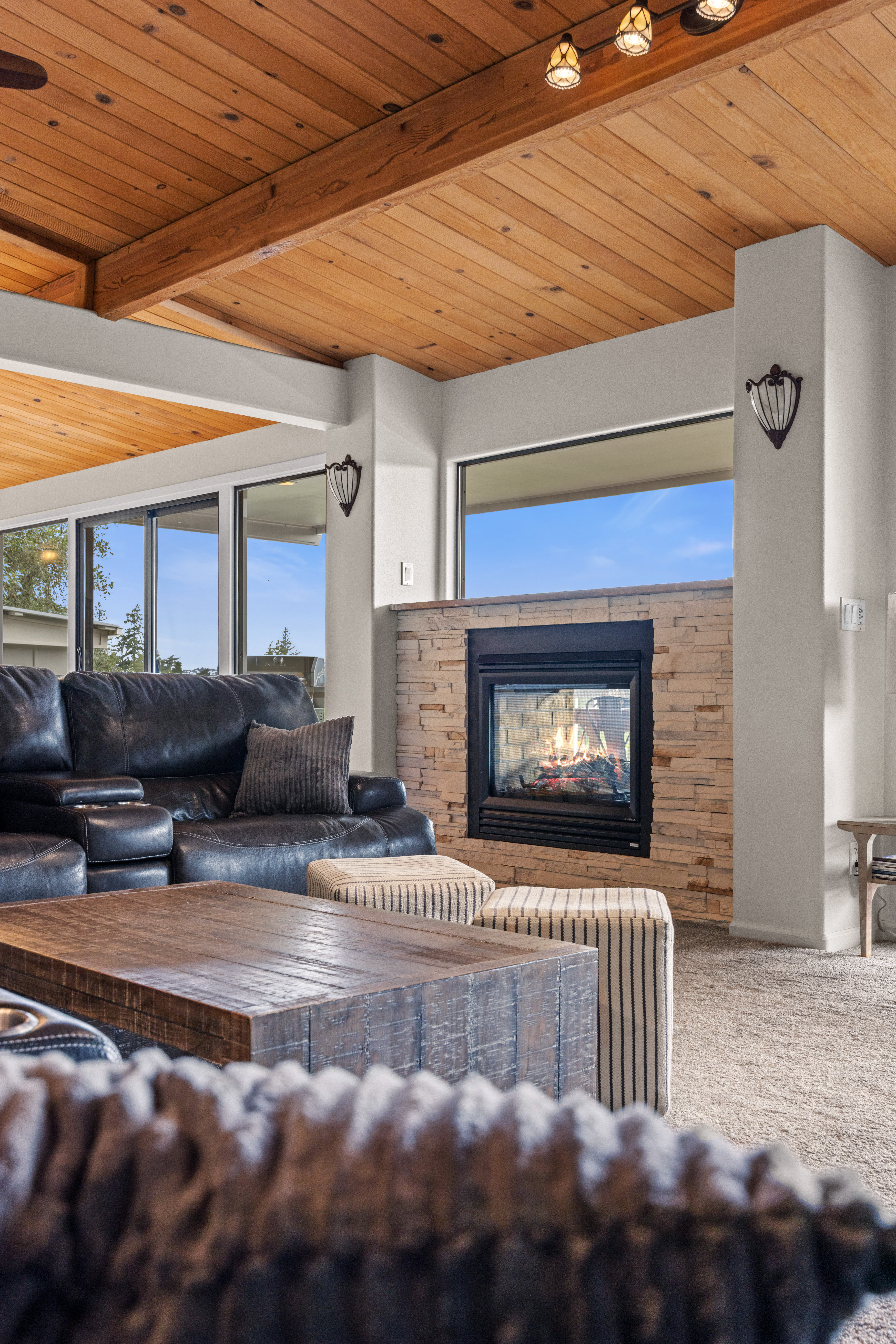 Cozy great room with vaulted wood ceilings and a stone fireplace