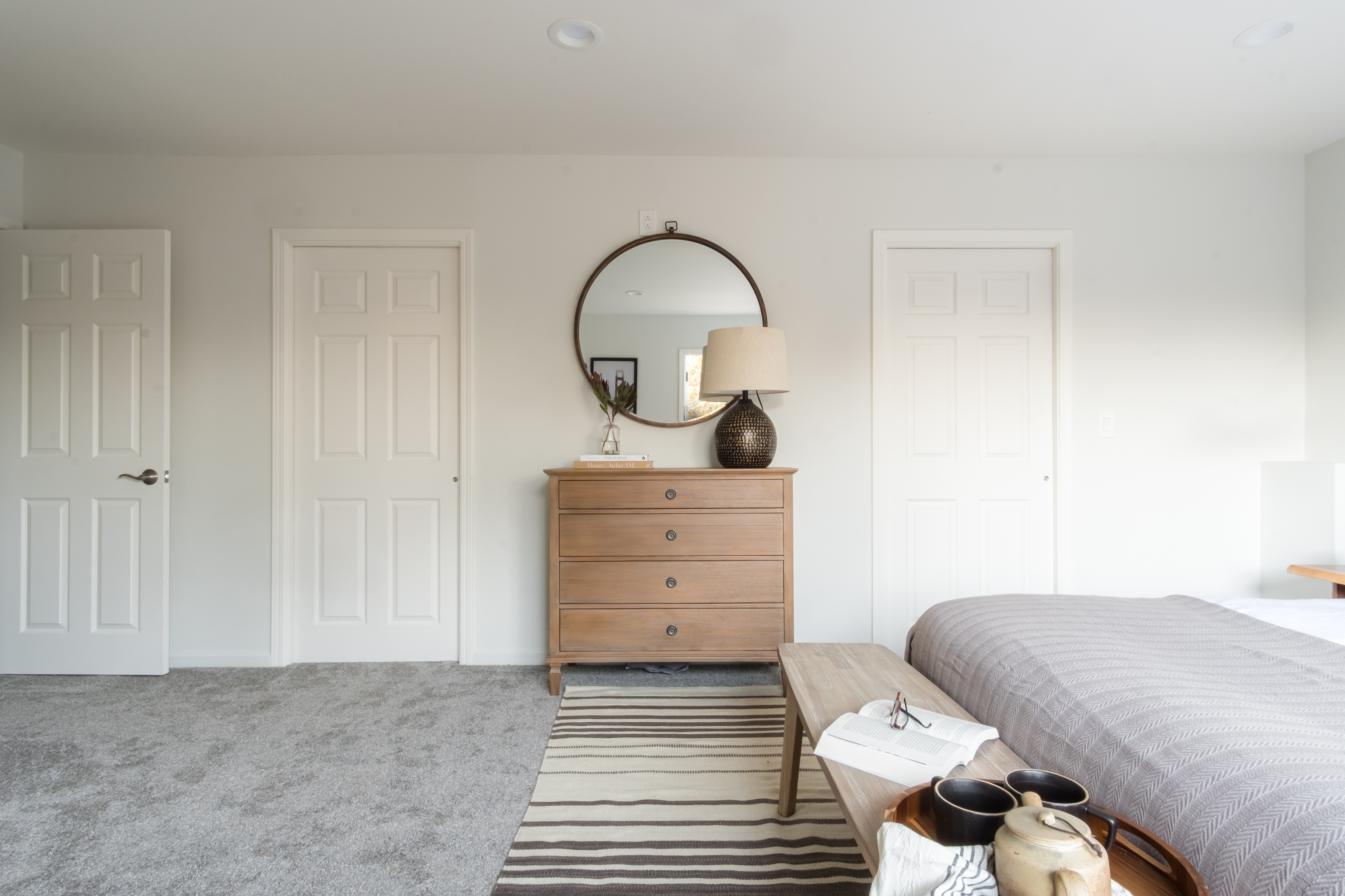 Bright, spacious bedroom with plush carpet and warm modern touches