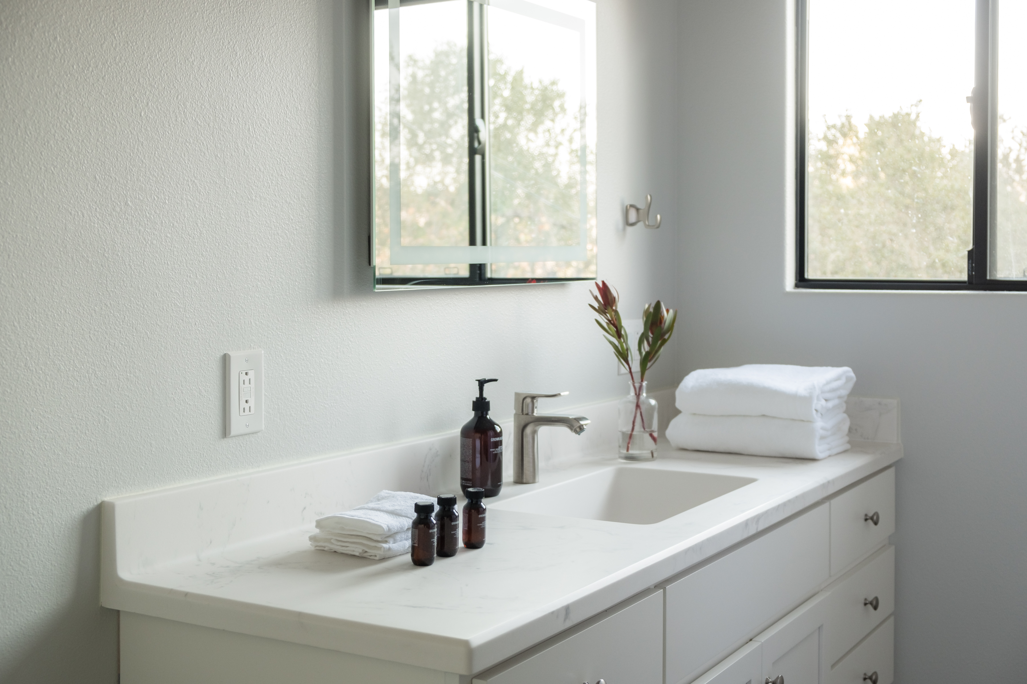 Bright spa-like bathroom with natural light and a sleek modern vanity