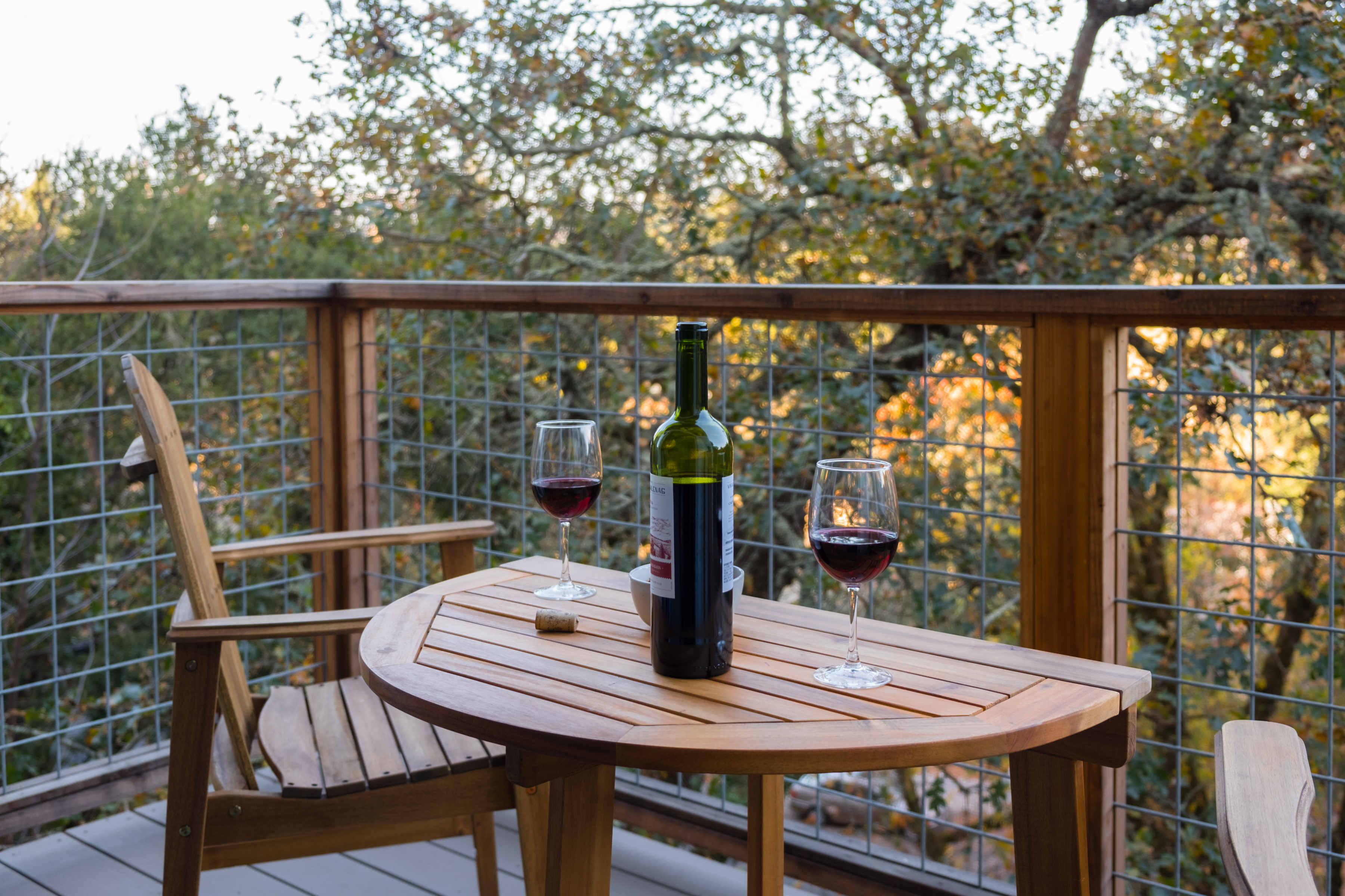 Private treetop deck with wine seating and peaceful wooded views