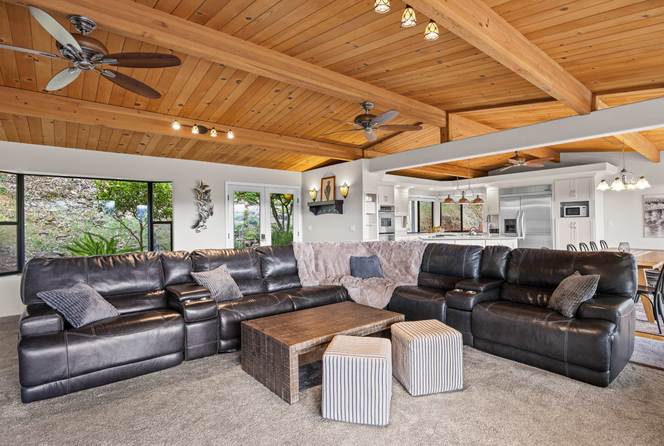 Spacious great room with vaulted wood ceilings and oversized sectional seating
