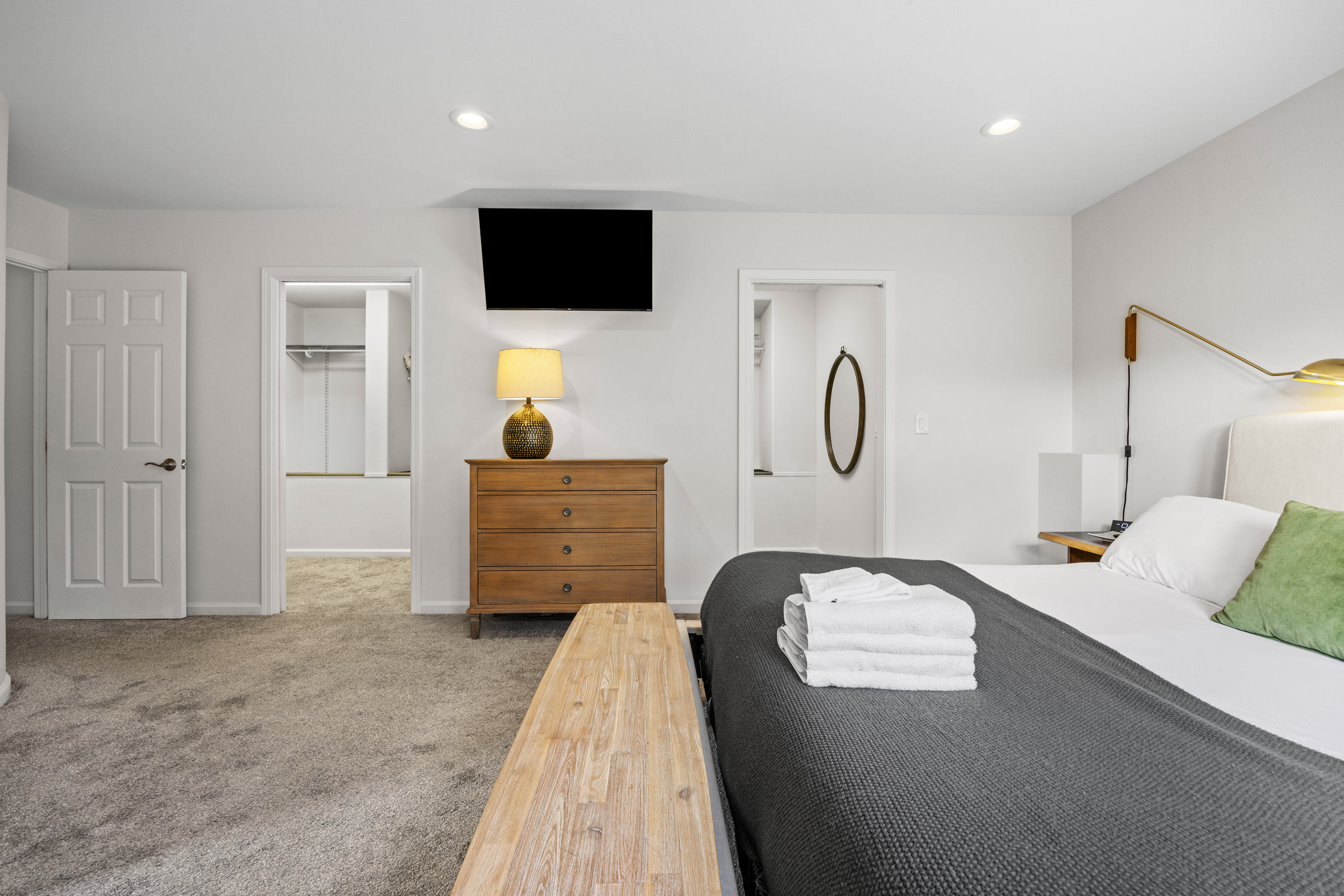 Spacious, bright bedroom with TV, workspace, and ample closet space
