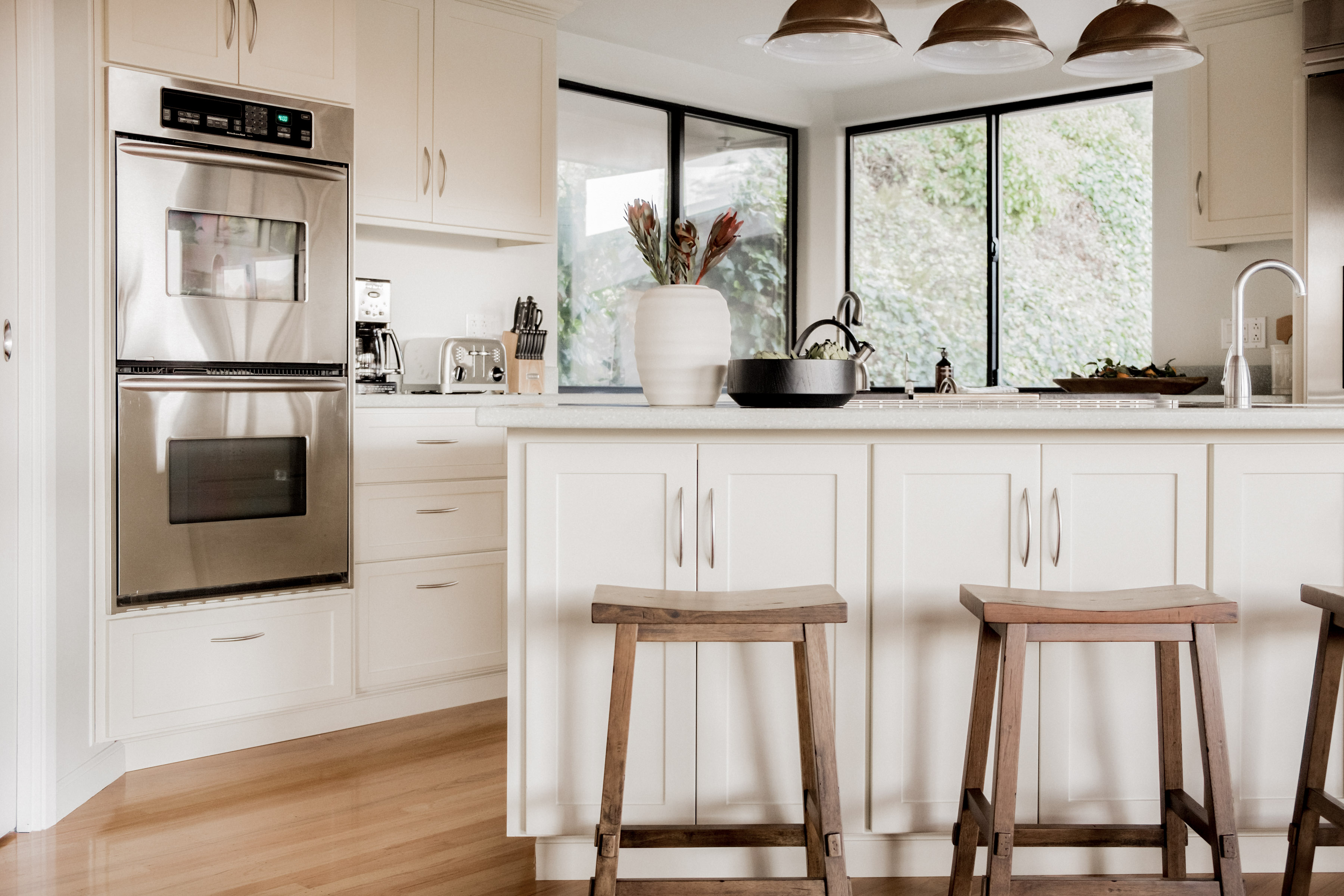 Bright modern kitchen with island seating and sun-filled corner windows
