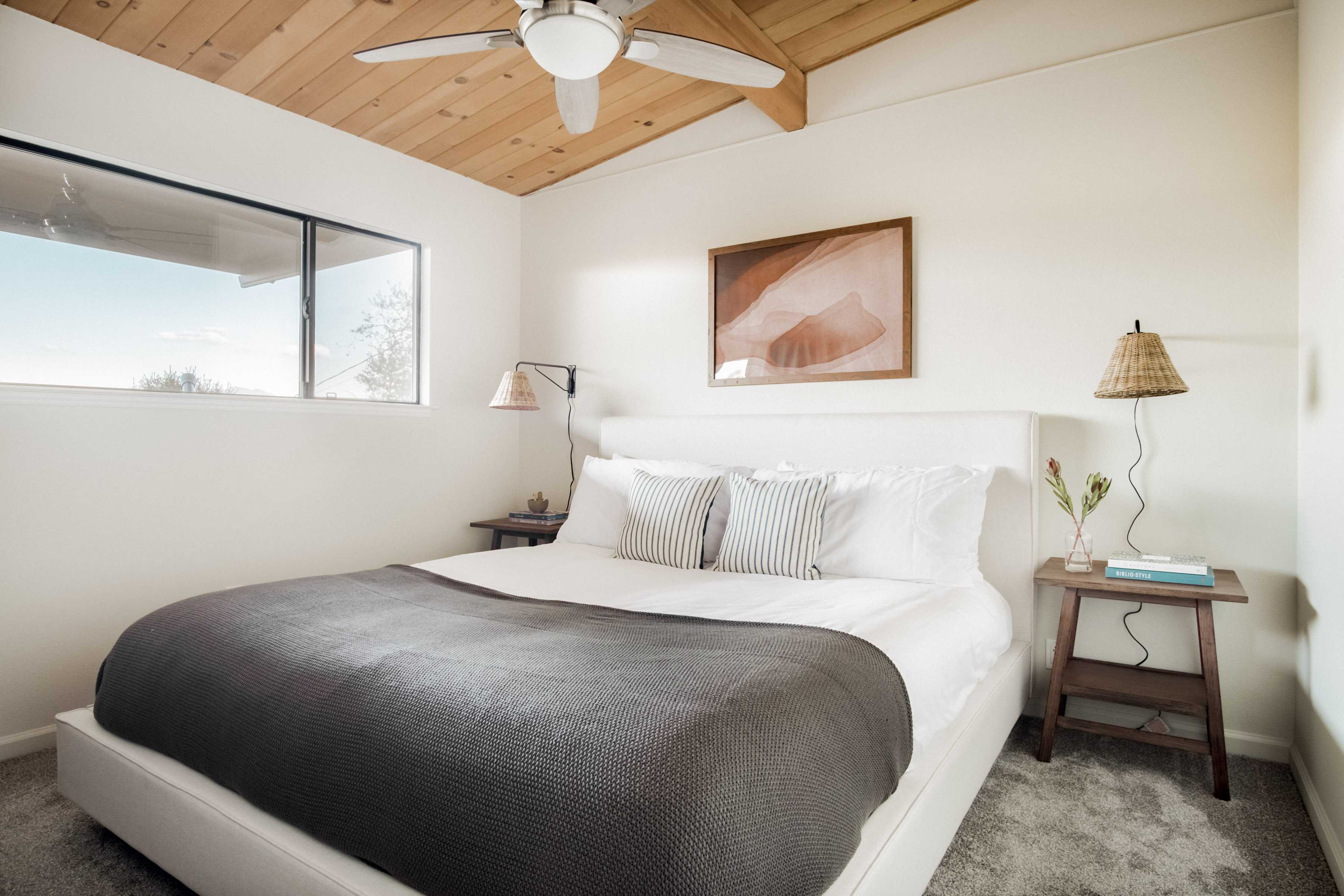 Bright bedroom retreat with vaulted wood ceilings and a plush king bed