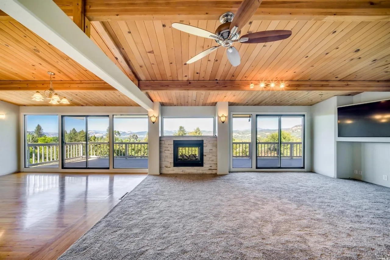 Open living with wood ceilings, fireplace & sweeping view deck