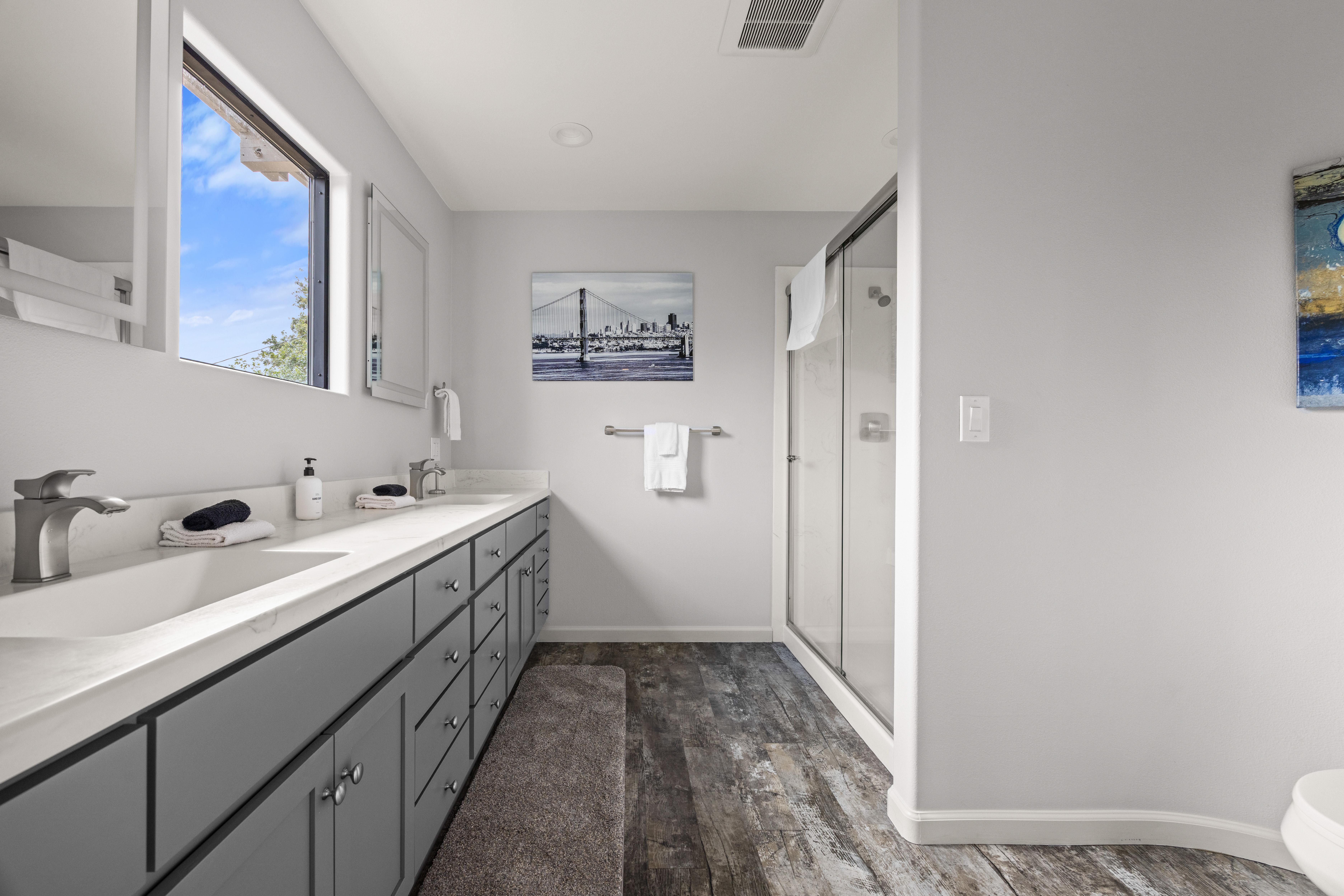 Bright spa-like bathroom with double vanity and glass walk-in shower