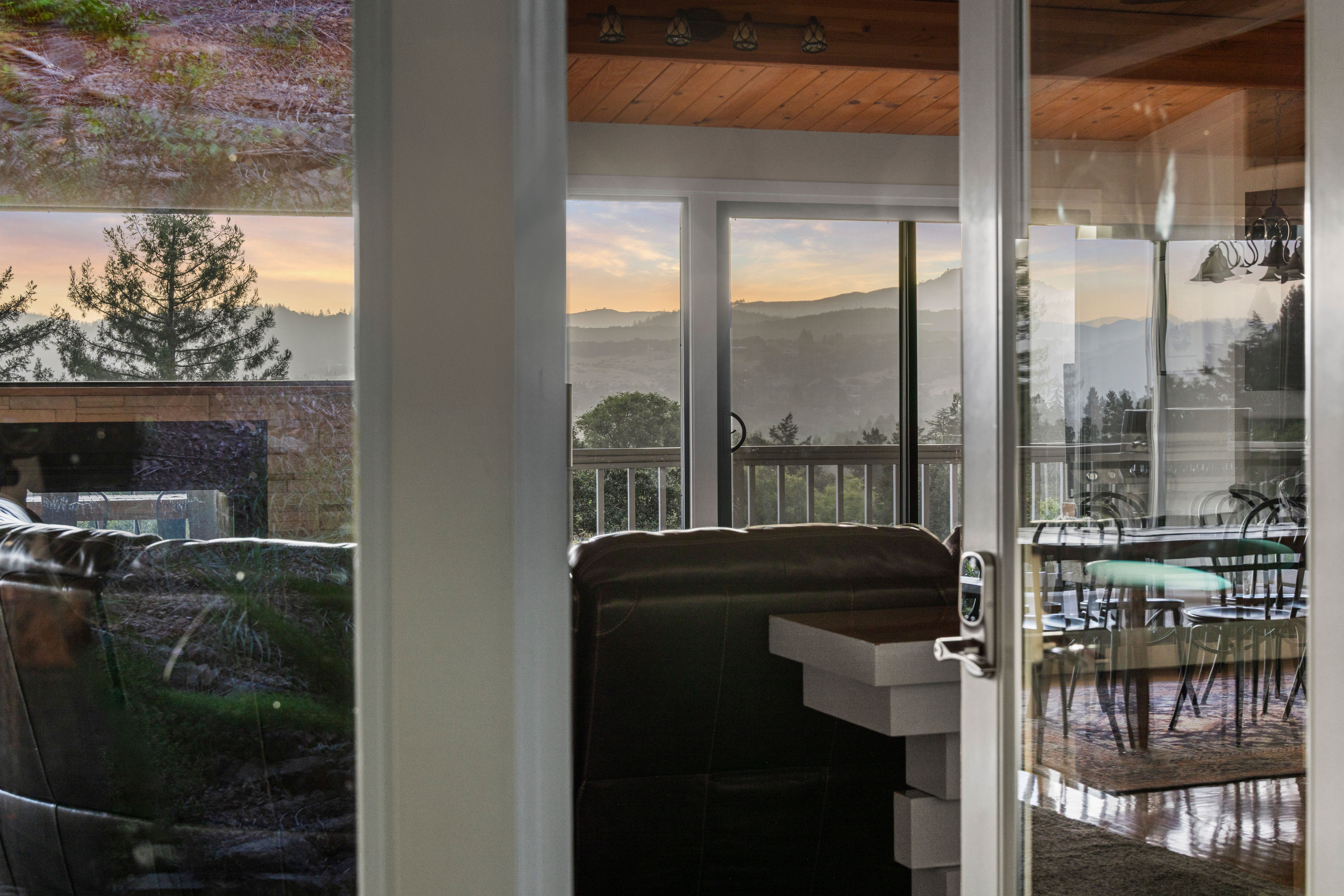 Cozy mountain-view interior with balcony access at sunset