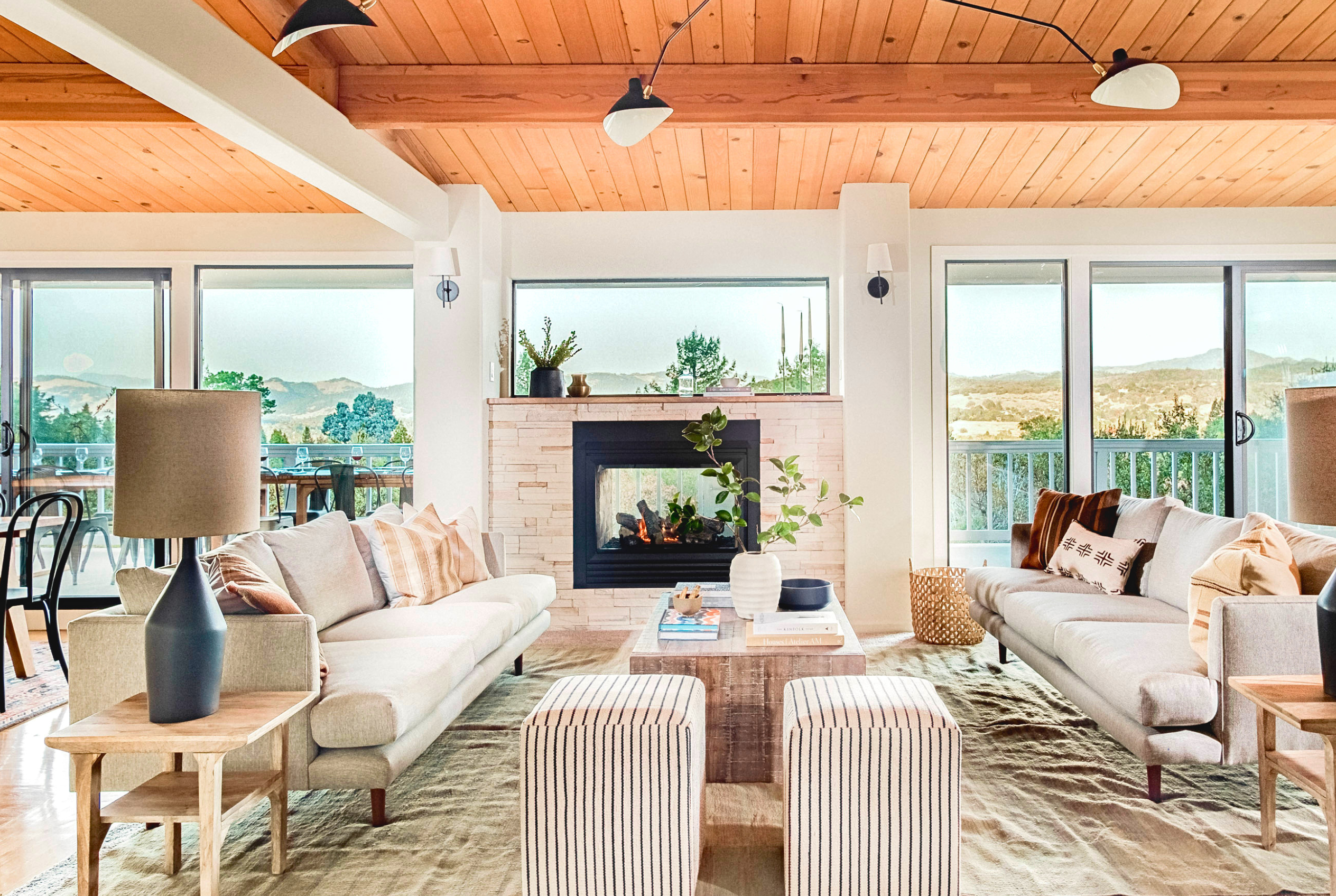 Sunlit living room with fireplace, vaulted ceilings, and mountain views