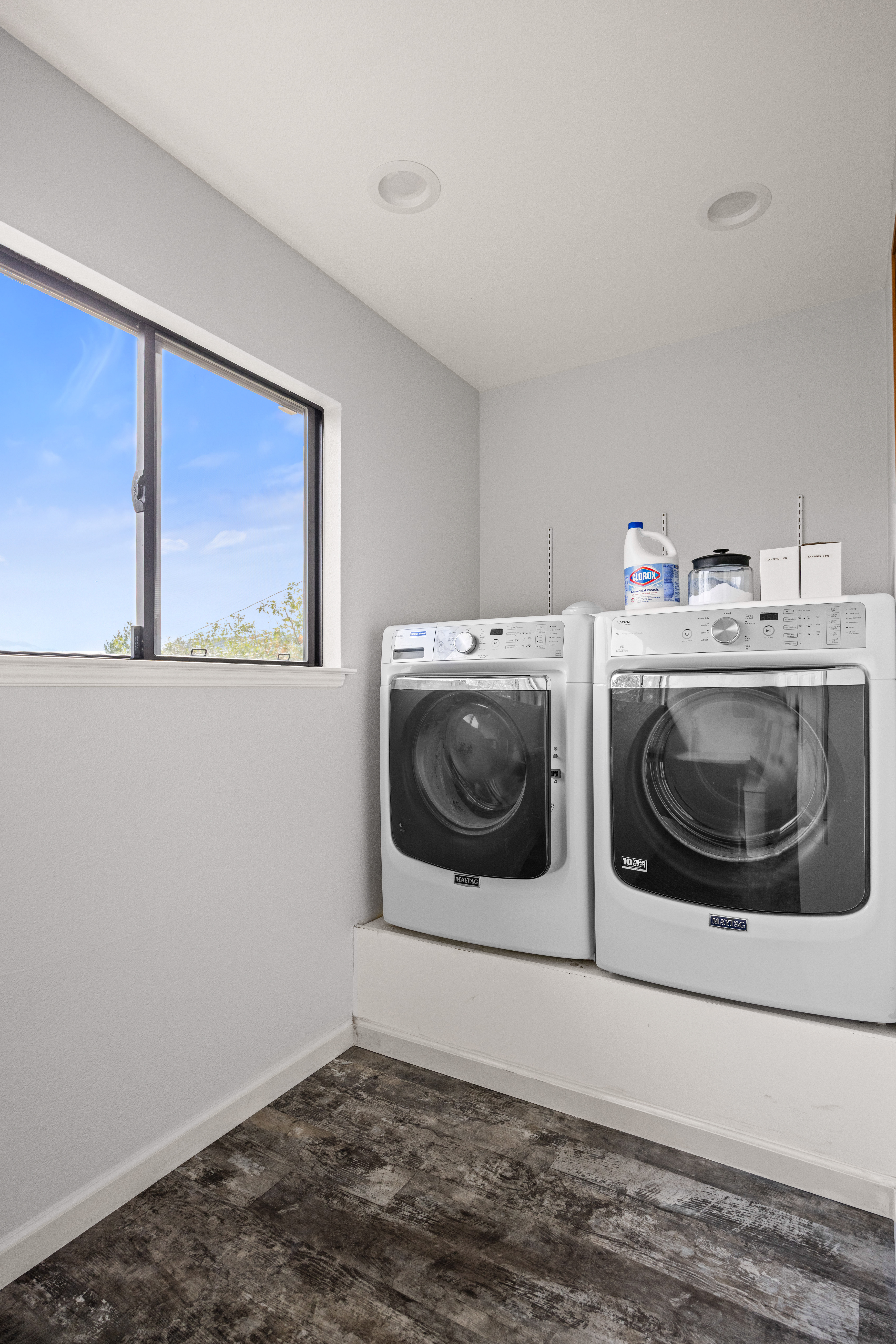 Bright laundry room with full-size washer, dryer, and natural light