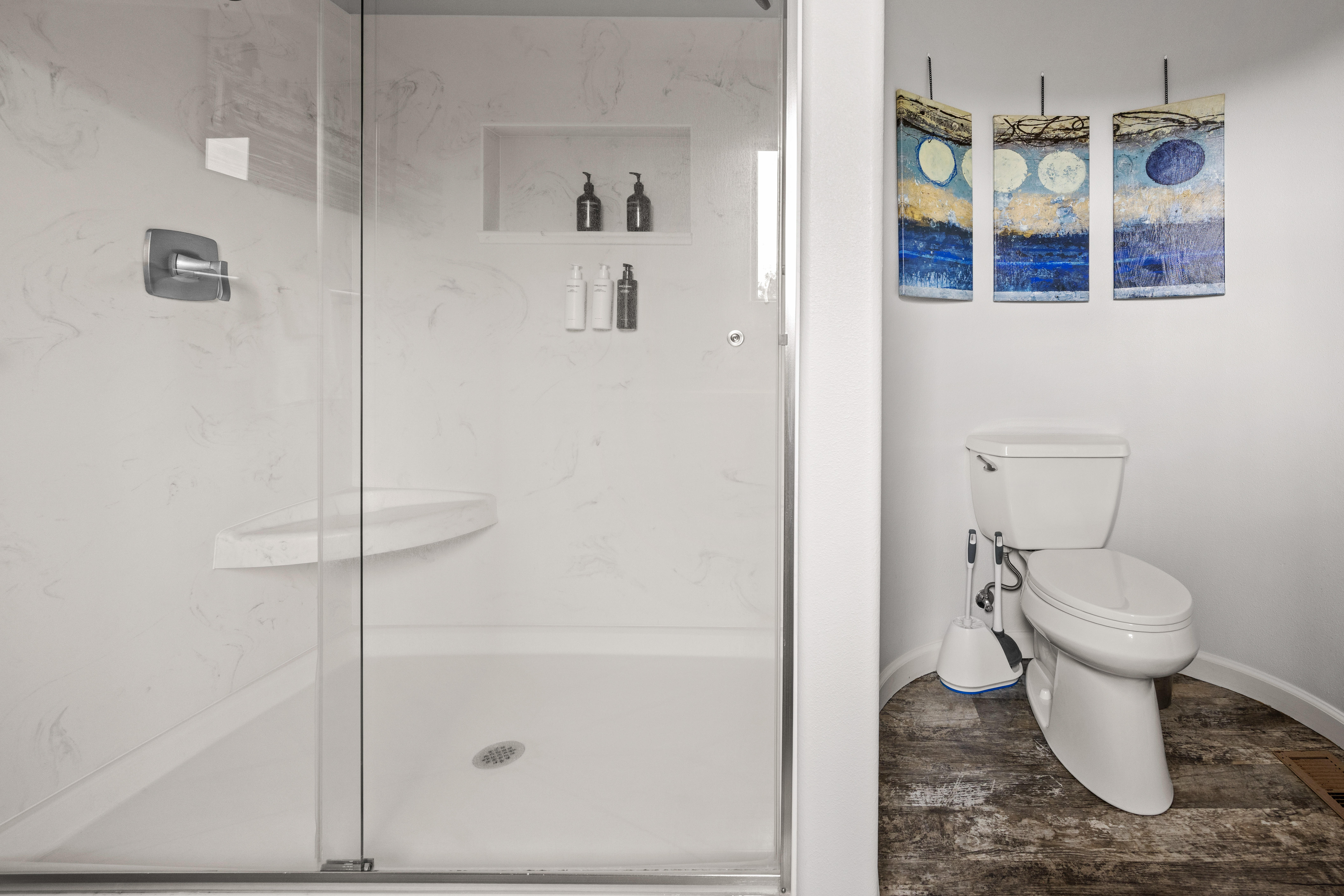 Bright modern bath with walk-in glass shower and stylish artistic touches