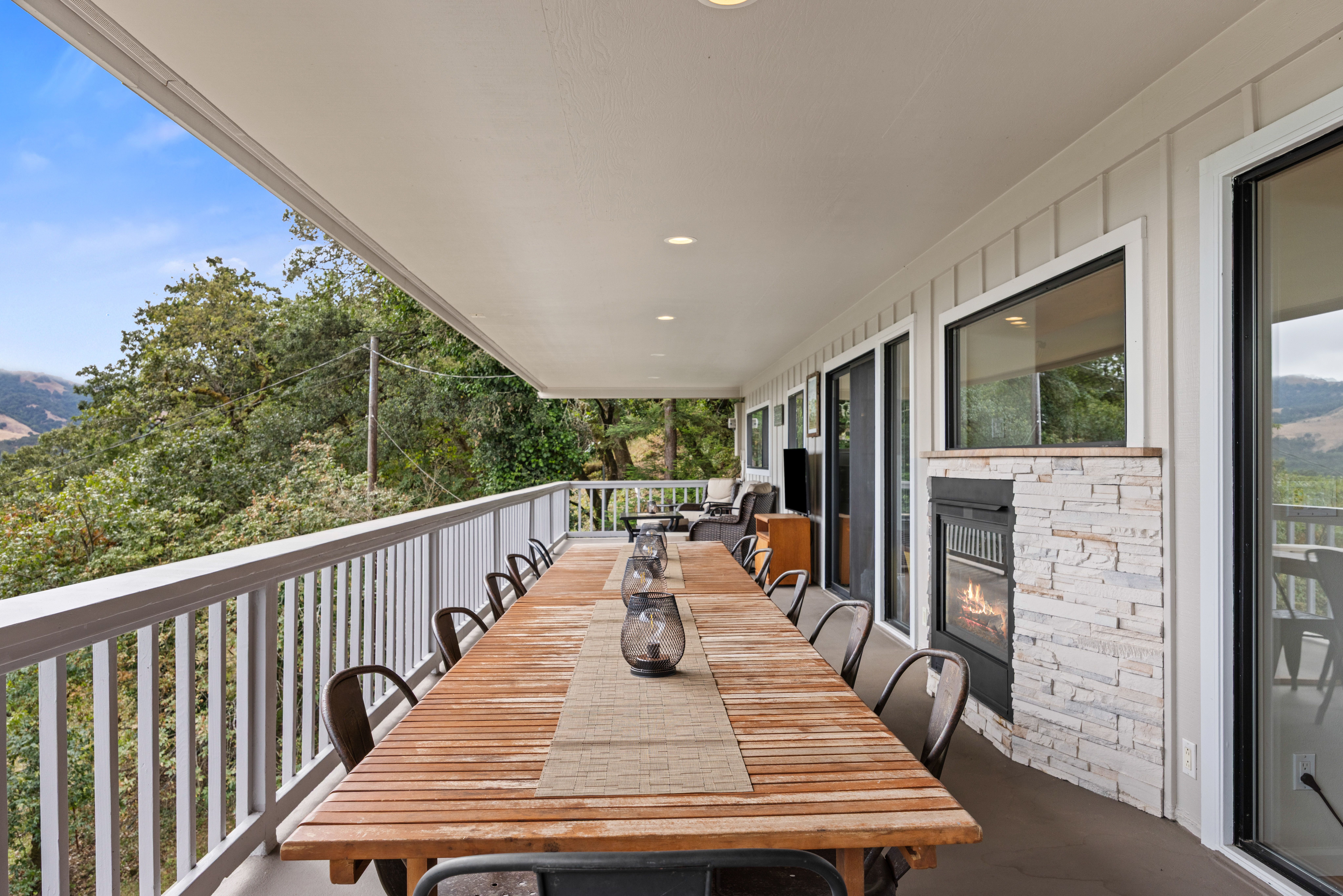 Covered mountain-view deck with fireplace and large outdoor dining table