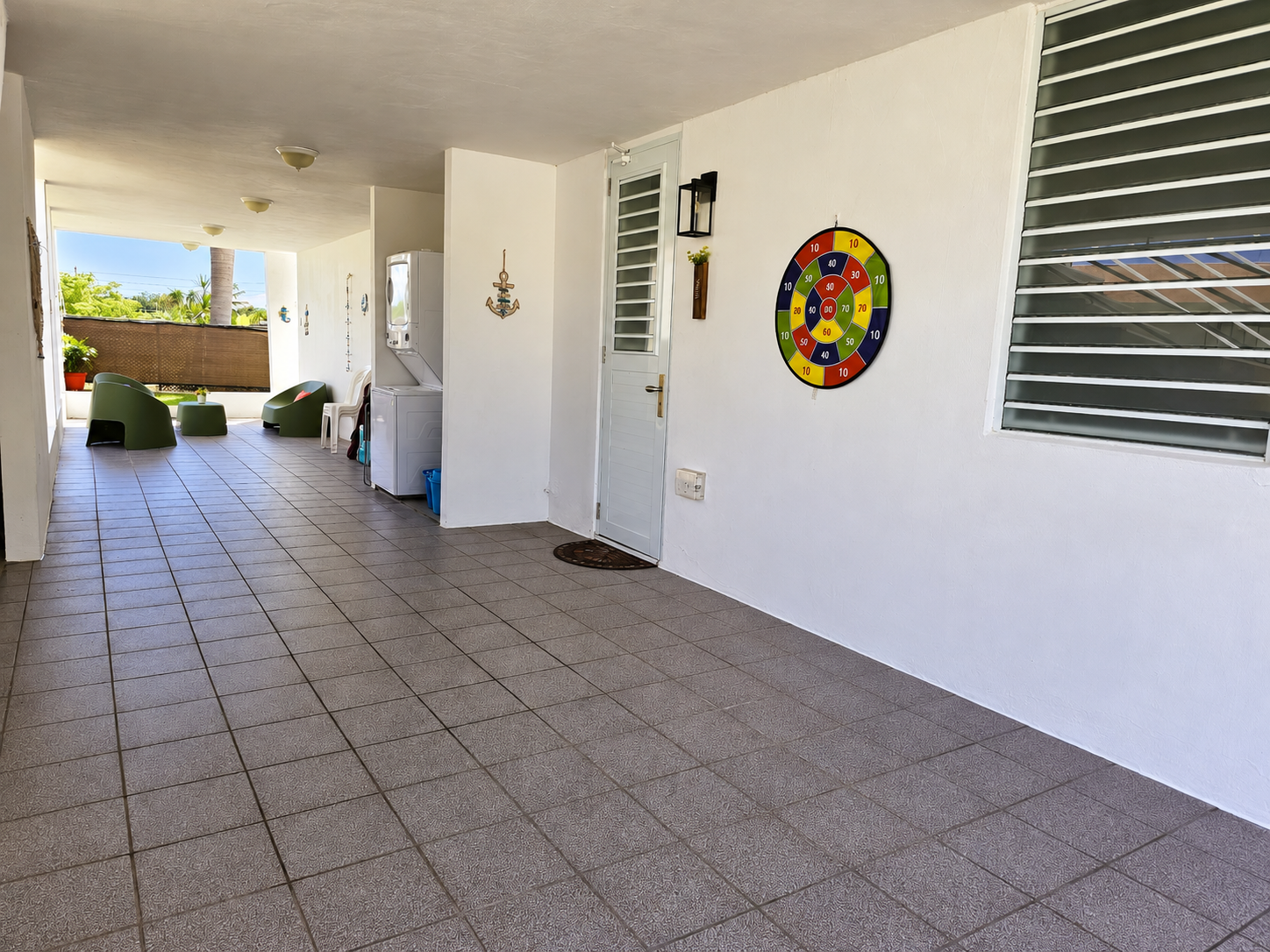Spacious covered patio with seating, laundry, and a fun dartboard area