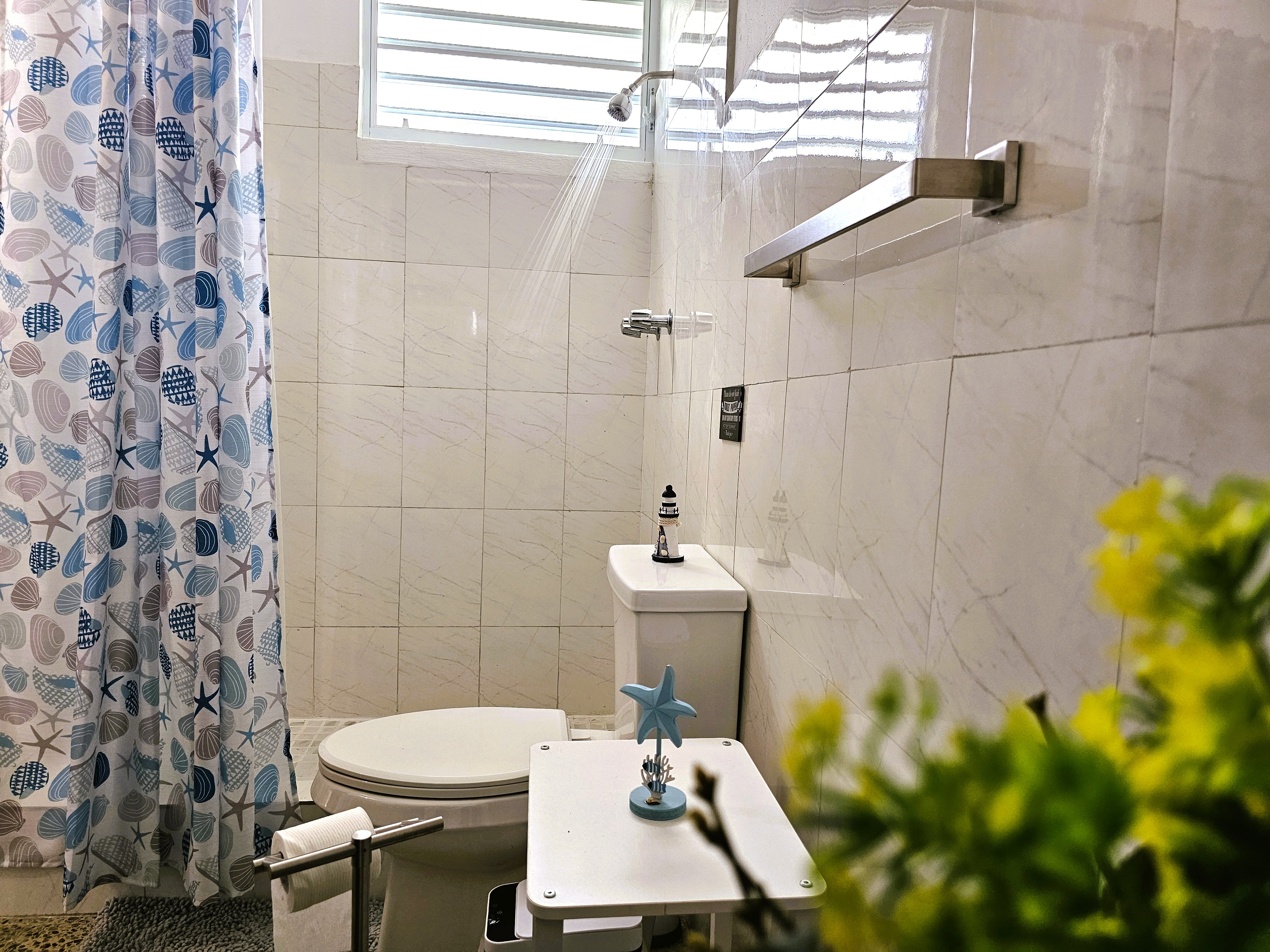 Bright coastal bathroom with rainfall shower and fresh modern finishes