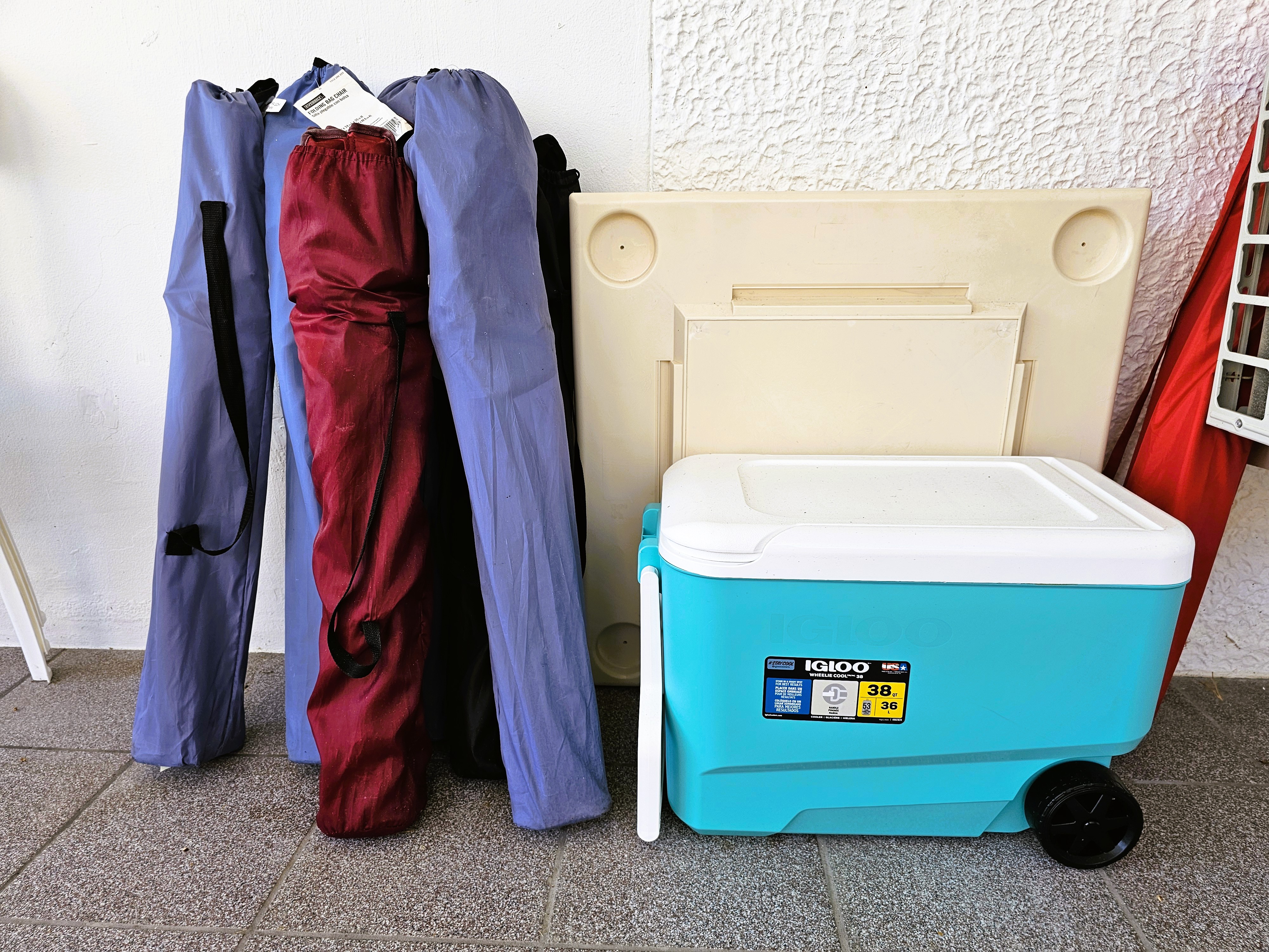 Beach-ready extras with portable gear and a large rolling cooler